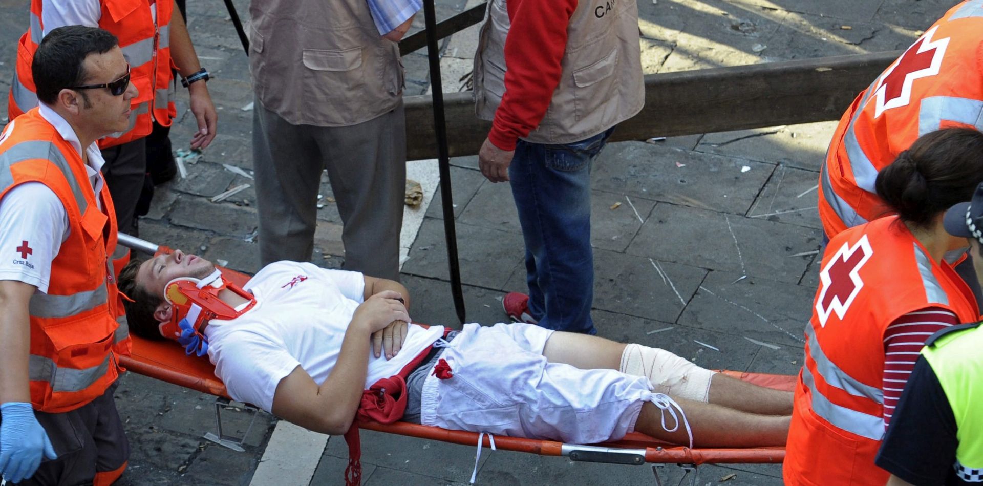 epa05414552 Red Cross' staff members evacuate on a stretcher US runner or 'mozo' W.R. after resulting injured during the second bull run of Sanfermines 2016 in Pamplona, northern Spain, 08 July 2016. At least five people were injured during the bull run. The festival, locally known as Sanfermines, is held annually from 06 to 14 July in commemoration of the city's patron saint and hundreds of thousands of visitors from all over the world attend the fiesta.  EPA/VILLAR LOPEZ