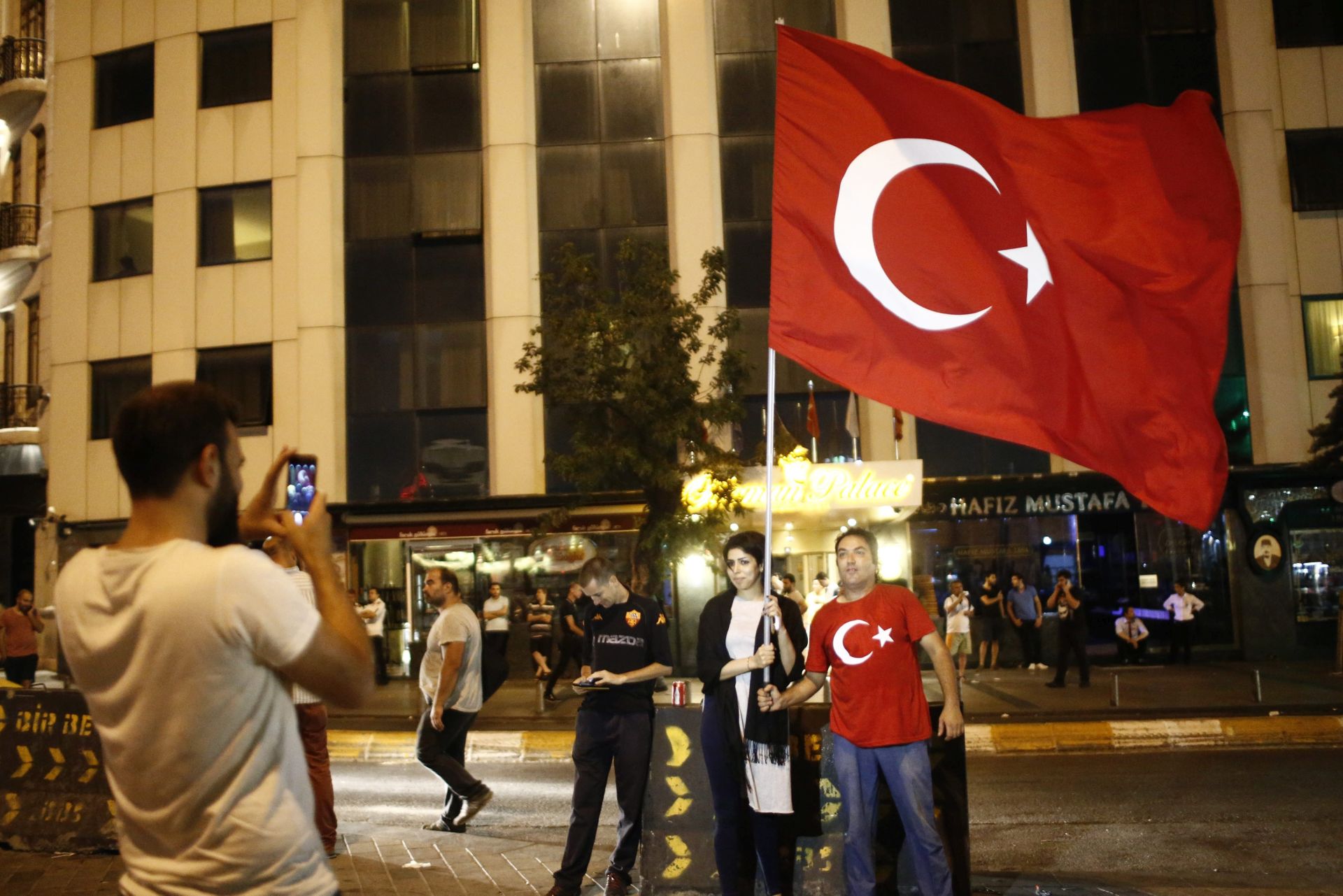 epa05427154 Supporters of President of Turkey Recep Tayyip Erdogan take pictures on a street at the Taksim Square in Istanbul, Turkey, 16 July 2016. Turkish Prime Minister Yildirim reportedly said that the Turkish military was involved in an attempted coup d'etat. The Turkish military meanwhile stated it had taken over control.  EPA/SEDAT SUNA