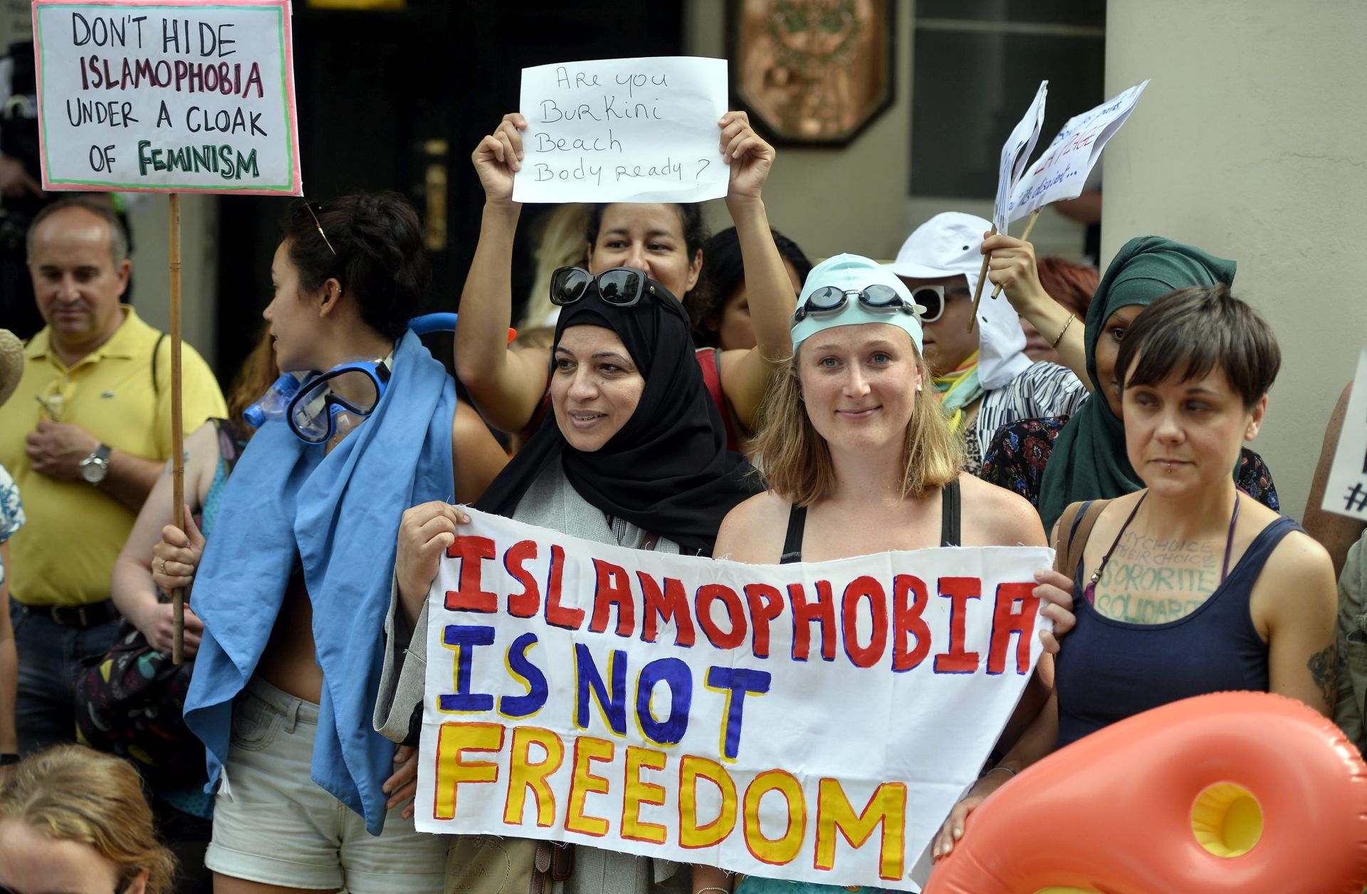 epa05509724 People participate in a 'Wear what you want beach party' protest outside of the French Embassy in London, Britain, 25 August 2016. The protest is to show solidarity with French Muslim women and to call for the repeal of law by the French Government banning 'burkini's' on the beach.  EPA/HANNAH MCKAY