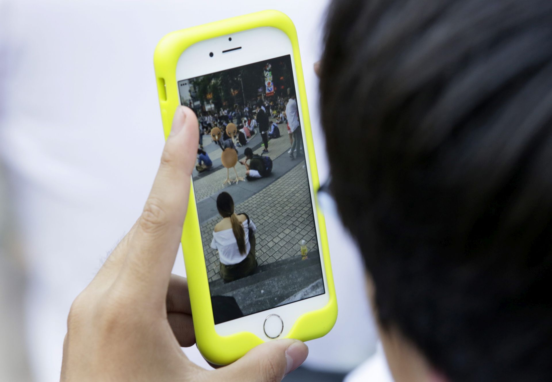 epa05440134 People play Pokemon Go at a park in Tokyo, Japan 25 July 2016. The game, released in Japan on 22 July 2016, that uses the GPS to locate the smartphone's location, has gained a huge popularity among smartphone users and added to the value of Nintendo that partly owns the franchise enterprise that makes Pokemon. Japanese government has issued a warning to use this game. The game has resulted minor bicycle and car accidents with playing the game in Japan.  EPA/KIMIMASA MAYAMA