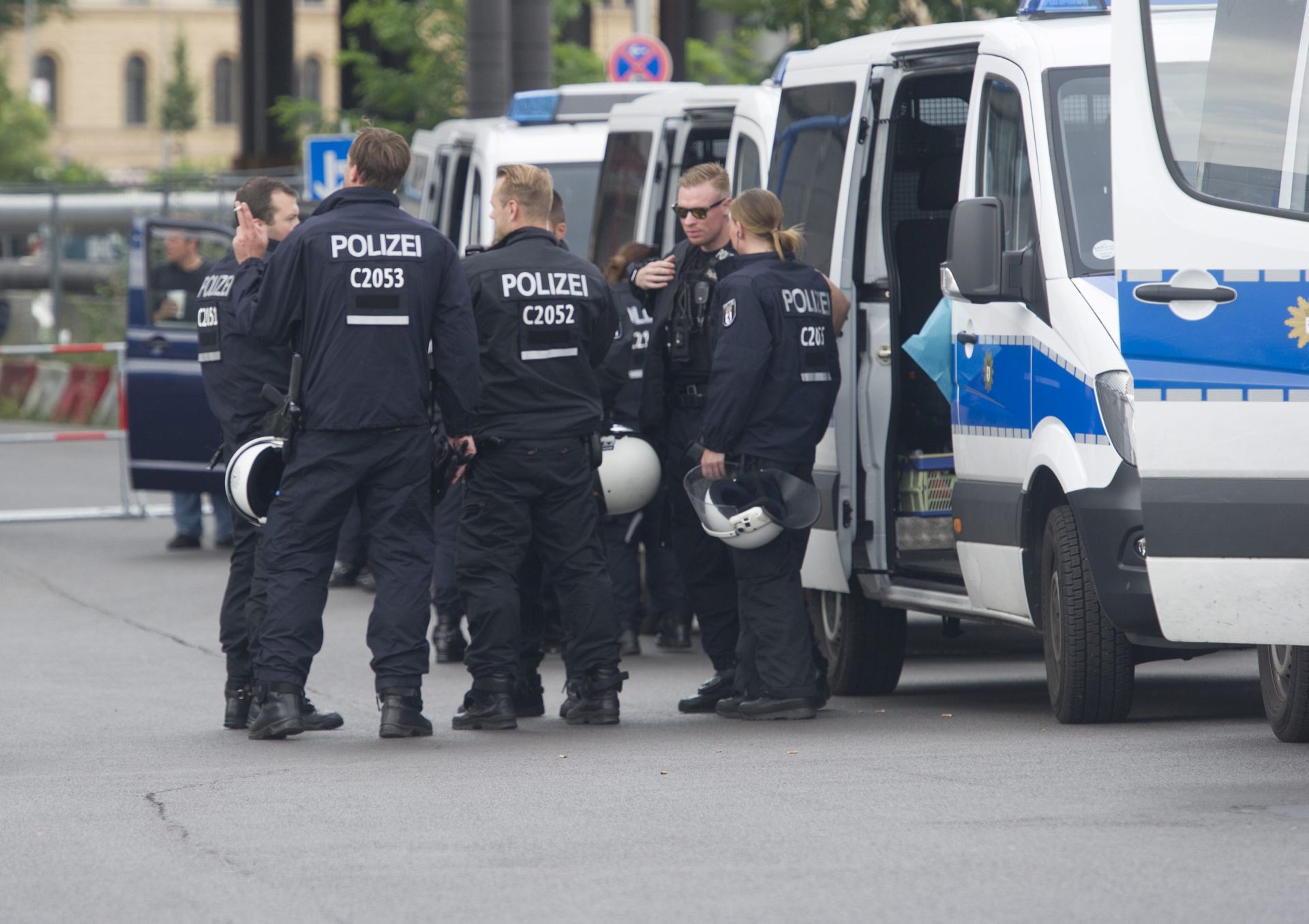 epa05448710 Police officers stand on the margins of a demonstration of right-wing populist and right-wing extremist groups on Washington Square at the central railway station in Berlin, Germany, 30 July 2016.  EPA/PAUL ZINKEN