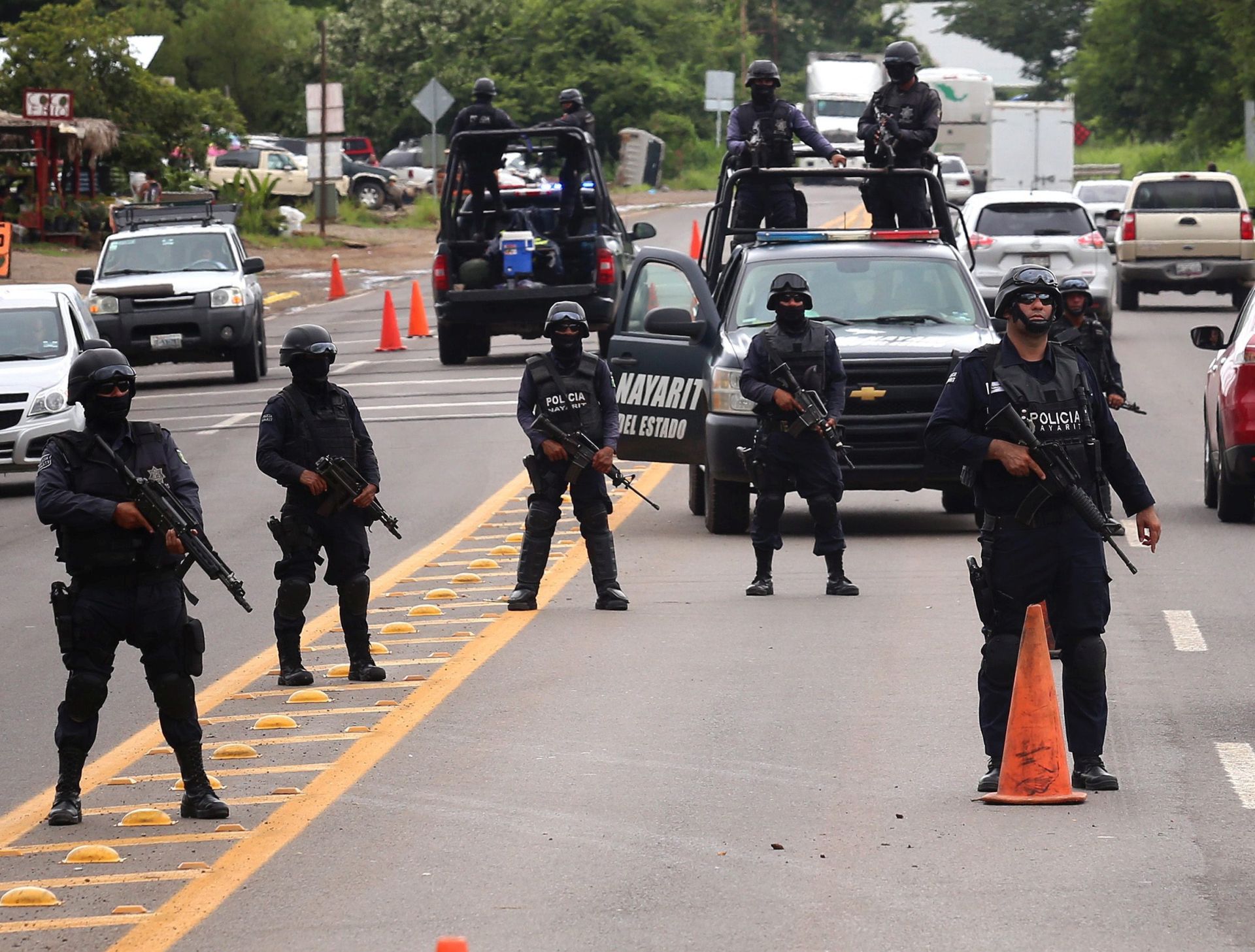 epa05495388 Nayarit State police officers stand guard at a check point near Nayarit, Mexico, 17 August 2016. Seven gunmen entered La Leche restaurant, located in downtown Puerto Vallarta, Jalisco State, on 15 August, reportedly kidnapping Guzman Salazar, 29, a son of Mexican drug lord 'El Chapo' Guzman, and his companions. The mass abduction was the work of the Cartel Jalisco Nueva Generacion (New Generation), which was created in 2010 as a cell of the Chapo-led Sinaloa drug cartel, an attorney general said on 16 August.  EPA/ULISES RUIZ BASURTO