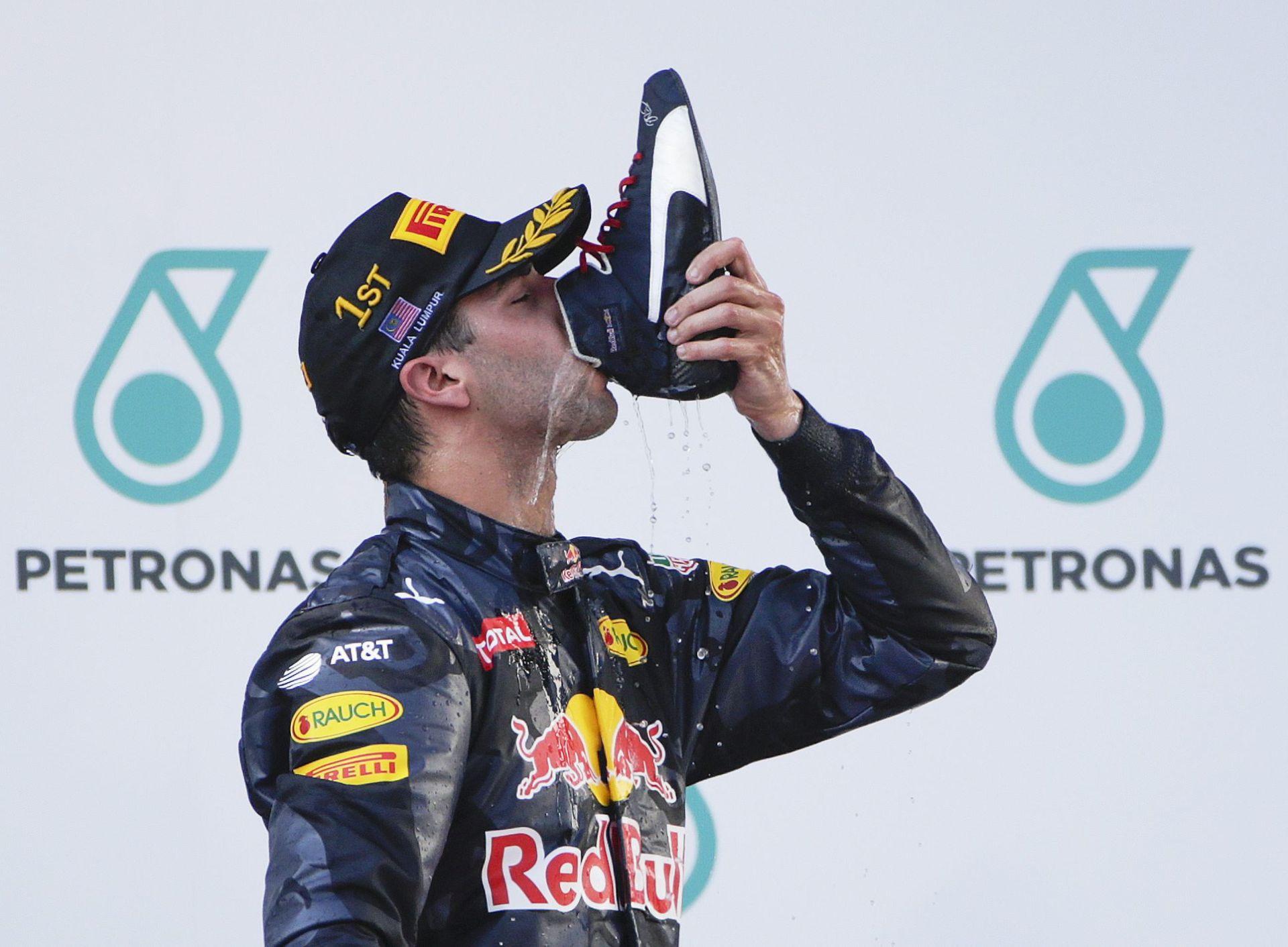 epa05566184 Australian Formula One driver Daniel Ricciardo of Red Bull Racing drinks champagne out of his shoe after winning the Malaysian Formula One Grand Prix in Sepang, Malaysia, 02 October 2016  EPA/FAZRY ISMAIL
