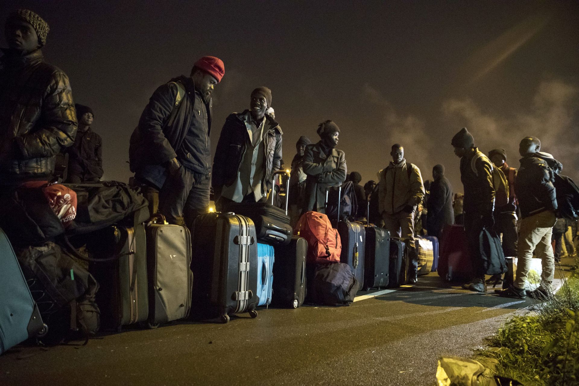 epa05600415 Migrants wait for their evacuation next to the makeshift camp 'the Jungle' as its dismantlement begins in Calais, France, 24 October 2016. The camp gathering more than 7,000 migrants will start being dismantled, a process that shall take a week according tho the French authorities.  EPA/ETIENNE LAURENT