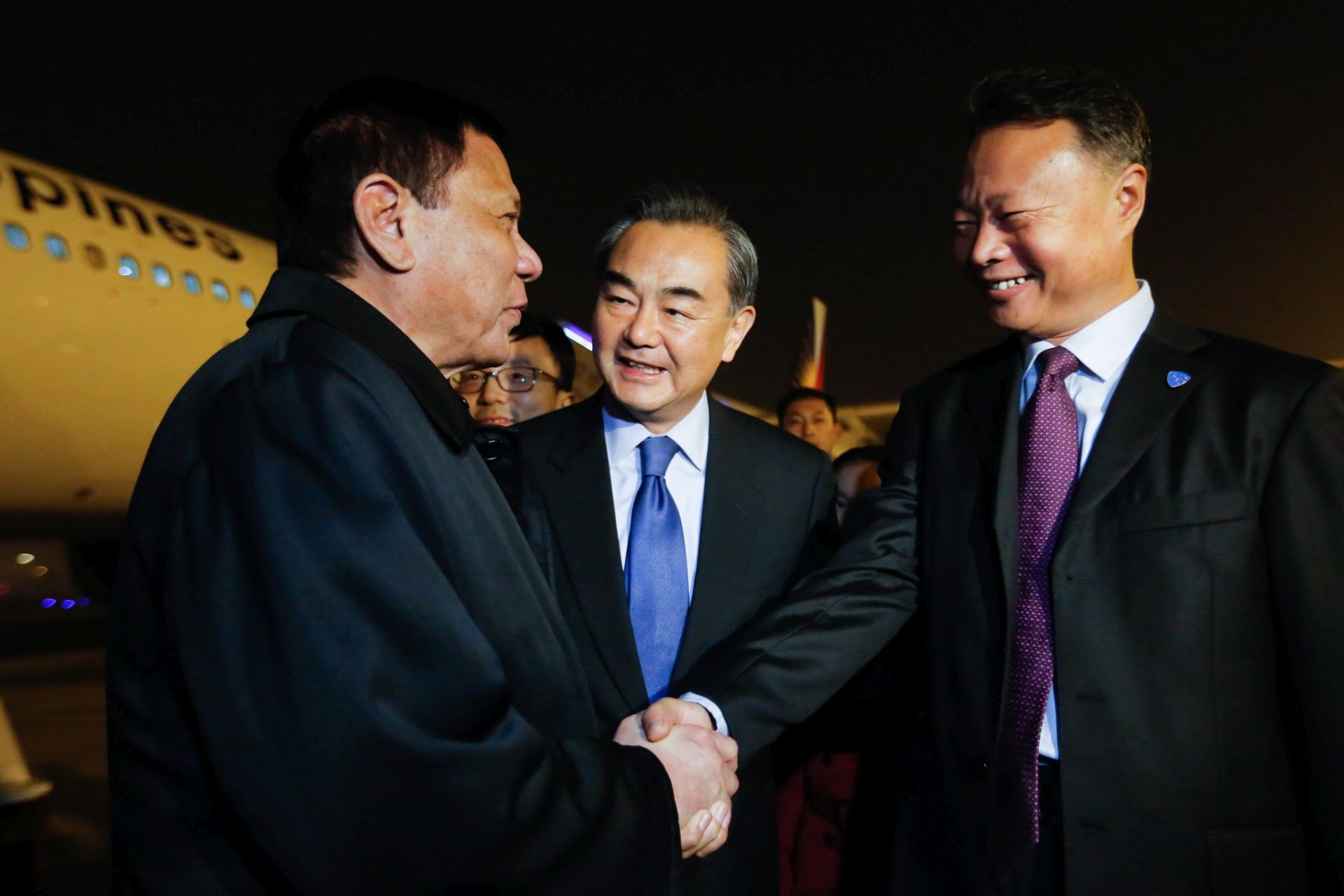 epa05591897 A handout picture by the Presidential Photographers Division (PPD) shows Filipino President Rodrigo Duterte (L) shaking hands with Chinese ambassador to the Philippines Zhao Jianhua (R) as Chinese Foreign Minister Wang Yi (C) looks on during his arrival in Beijing, China, 19 October 2016. Duterte is in China for a four day visit to meet with Chinese President Xi Jinping, Premier Li Kequiang and members of the Filipino community.  EPA/TOTO LOZANO / PRESIDENTIAL PHOTOGRAPHERS DIVISION / HANDOUT  HANDOUT EDITORIAL USE ONLY/NO SALES