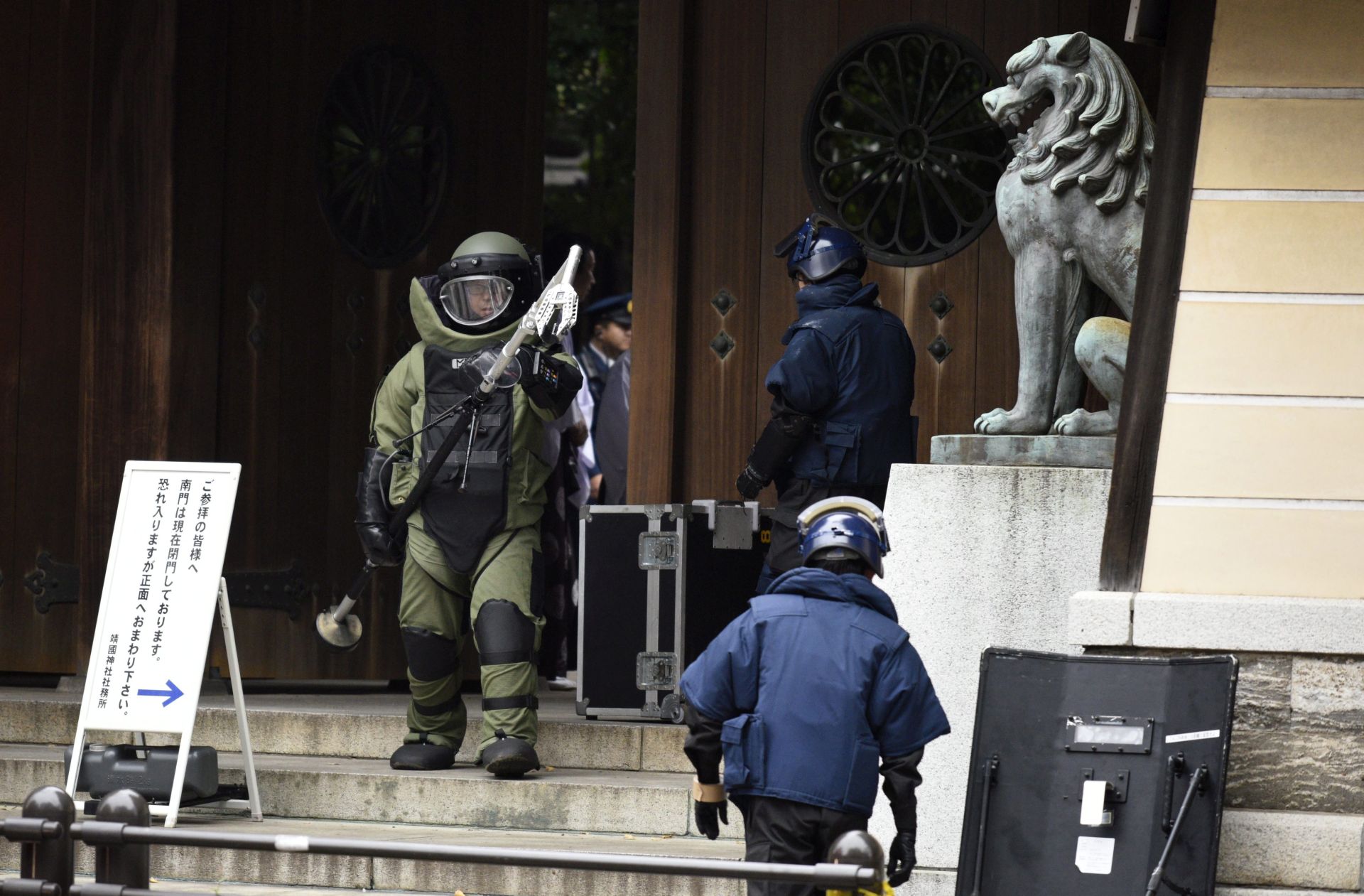 epa05038093 A bomb squad member wearing heavy equipment leaves the explosion site at the Yasukuni shrine precints in Tokyo, Japan, 23 November 2015. More than 100 police, firefighters and officials gathered at the site after an explosion was heard in the toilets of the Yasukuni Shrine, a controversial war shrine in the capital Tokyo. Local media reports said police found possible traces of an explosion, as well as batteries and wires at the shrine. There were no reports of injuries.  EPA/FRANCK ROBICHON