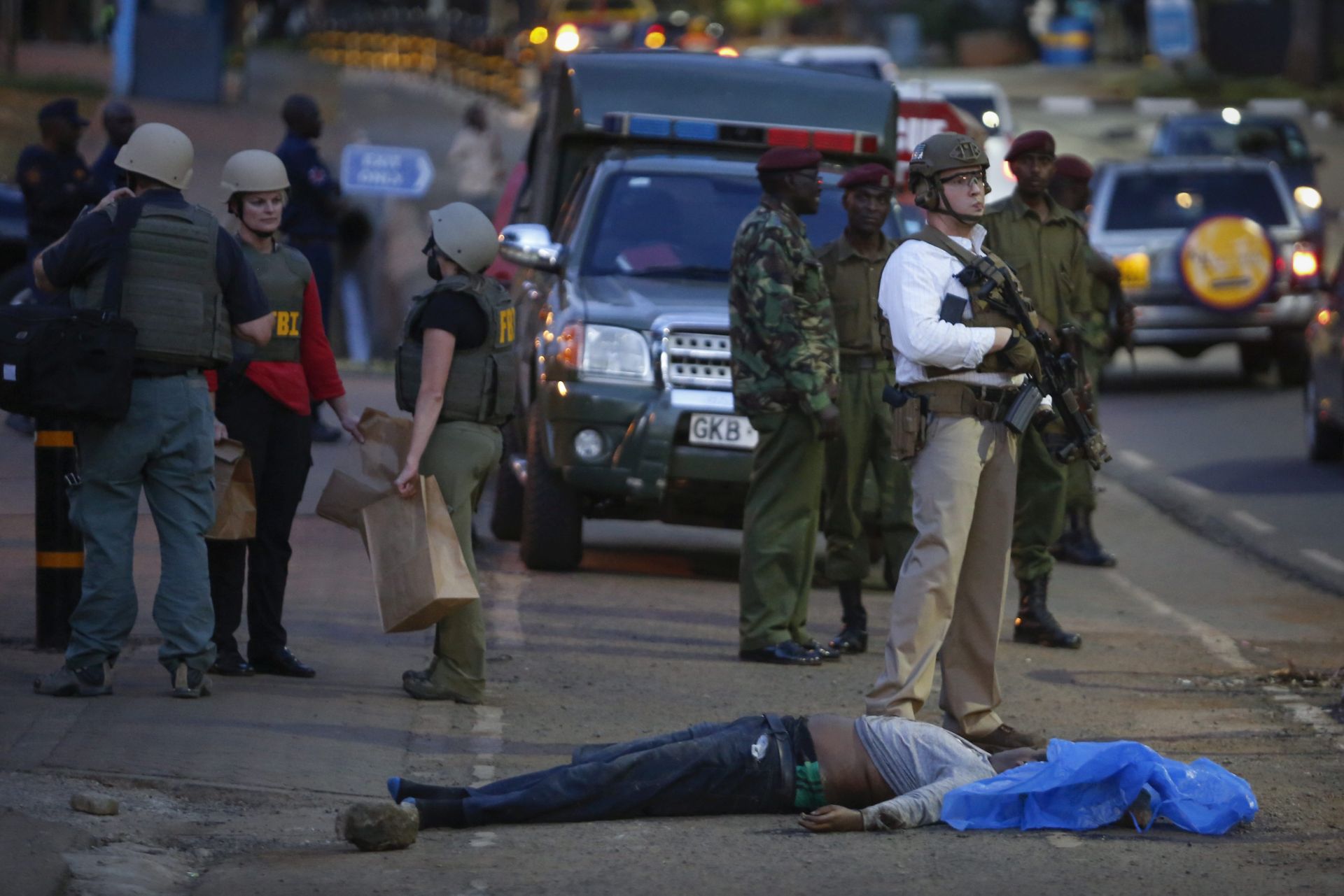 epa05606014 Kenyan police officers and FBI officers stand guard near the body of a man who was shot dead by Kenyan police in front of the US embassy in Nairobi, Kenya, 27 October 2016. Vitalis Otieno, the officer in charge of the area, told journalists that a pedestrian stabbed a police officer guarding the US embassy and tried to take his gun before being shot dead. Otieno said that the attacker is a Kenyan national from Wajir town in northeastern part of the country, close to the border with Somalia. The US embassy in a statement confirmed the shooting and said no embassy personnel were involved.  EPA/DAI KUROKAWA