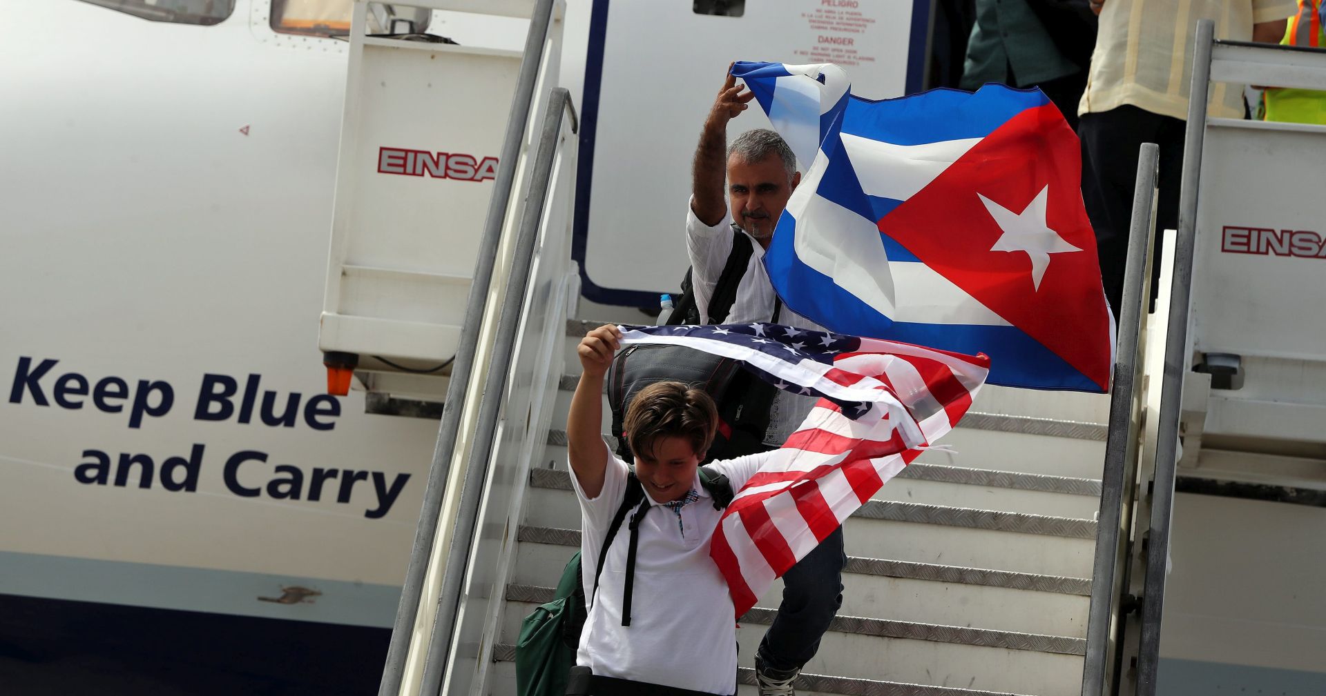 epa05517076 People waving Cuban and US national flags disembark from a plane from the US airline Jet Blue at the Abel Santamaria airport in the city of Santa Clara, Cuba, 31 August 2016. JetBlue Flight 387, the first commercial flight between USA and Cuba since 1961, landed in Santa Clara on 31 August, after a trade embargo prohibited tourist air service between the two countries for over fives decades.  EPA/ALEJANDRO ERNESTO