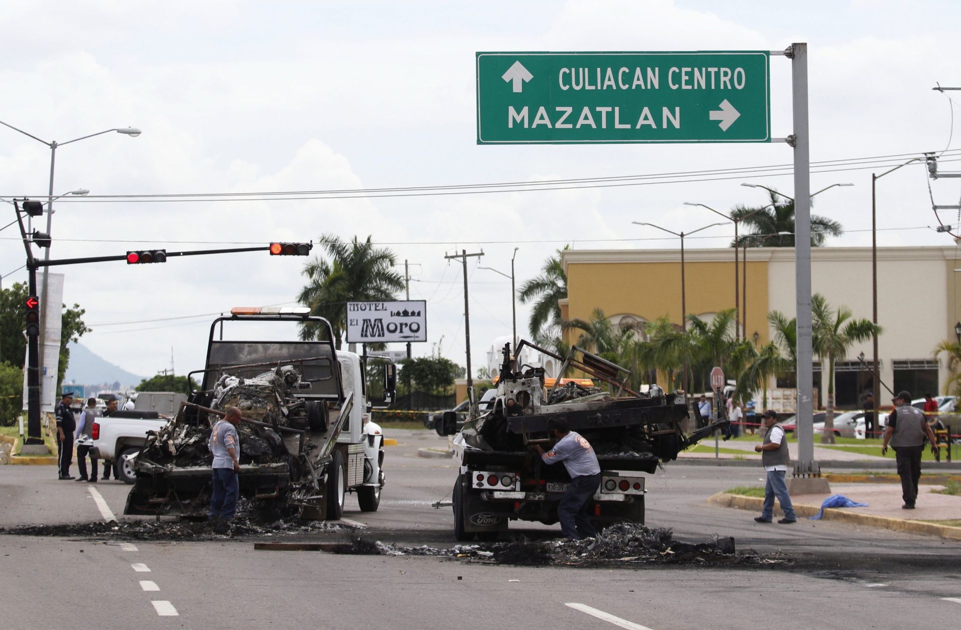 epa05564612 A handout picture made available by Noroeste Mazatlan on 01 October 2016 shows workers transporting next to burned vehicles away from a crime scene after an ambush perpetrated by alleged members of an organized crime syndicate, under orders of the sons of the Mexican drug lord Joaquin 'El Chapo' Guzman, in Culiacan, Sinaloa, Mexico, 30 September 2016. The ambush was allegedly organized to rescue a high ranking cartel member who was being transported to a hospital. At least five soldiers died in the attack and another eight were injured.  EPA/NOROESTE MAZATLAN / HANDOUT EDITORIAL USE ONLY/NO SALES HANDOUT EDITORIAL USE ONLY/NO SALES