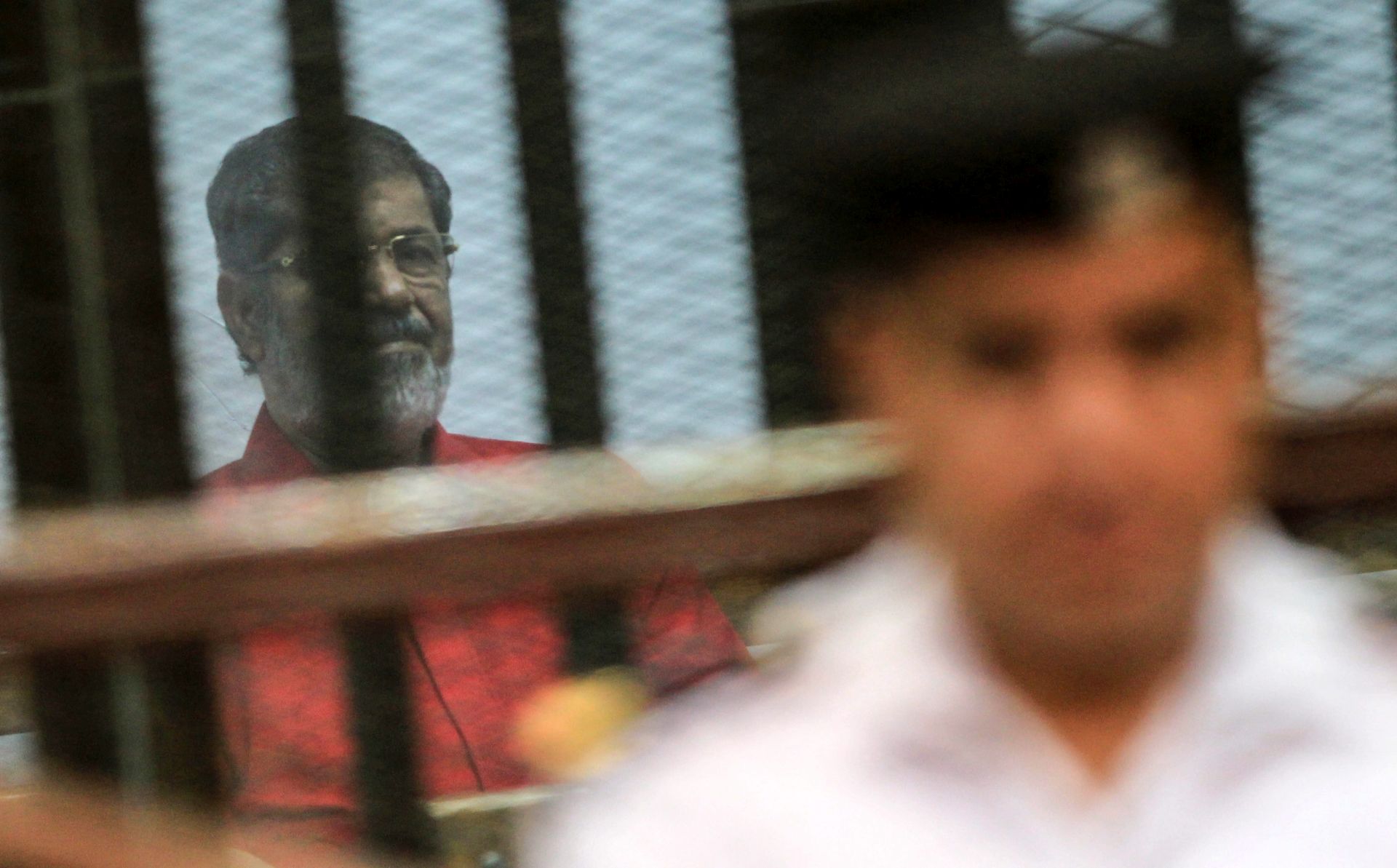 epa05374549 Ousted Egyptian President Mohamed Morsi looks on during a trial session on charges of espionage in Cairo, Egypt, 18 June 2016. A court sentenced ousted president Mohamed Morsi to life in prison as well as a 15-year prison sentence over charges of allegedly leaking classified documents related to national security to Qatar in exchange for payments. The court also confirmed death sentences against six co-defendants in the case.  EPA/MOHAMED HOSSAM