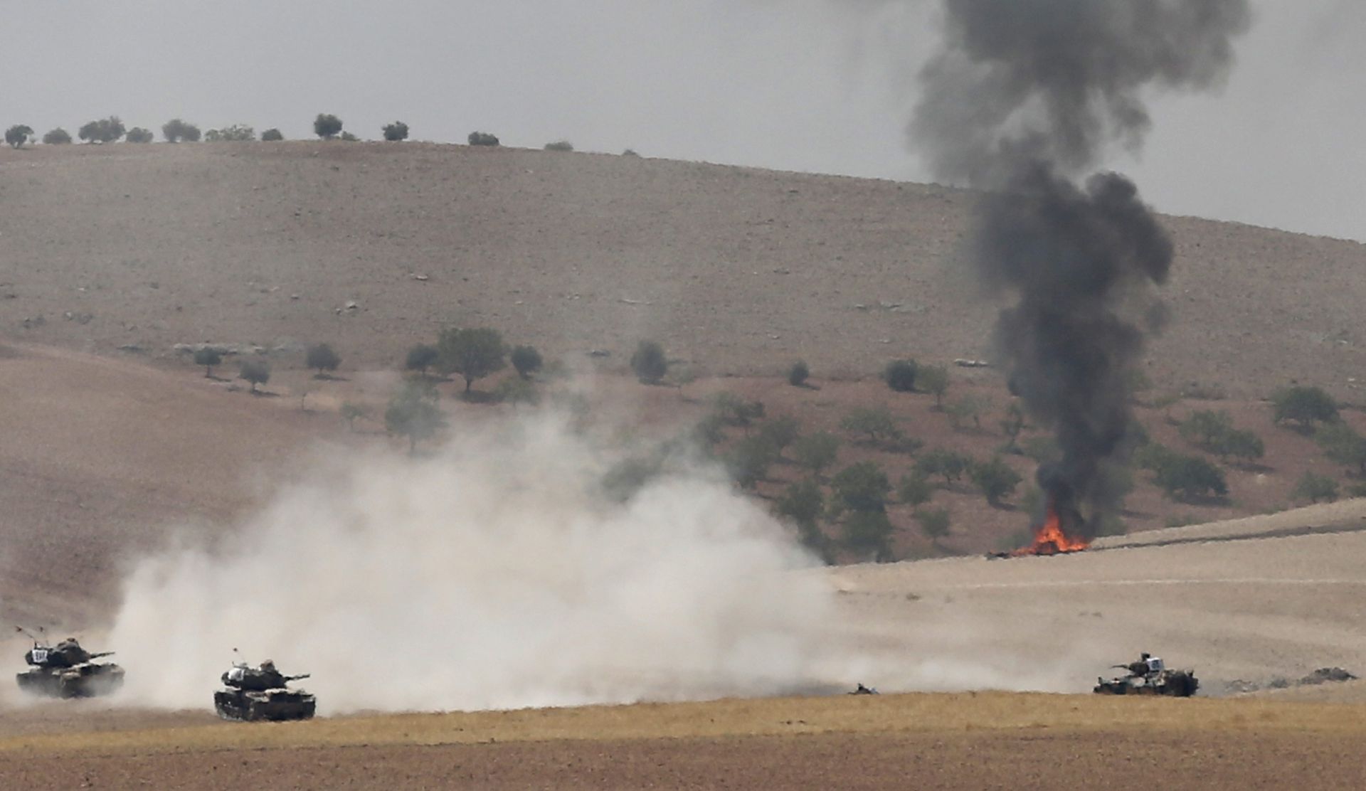 epa05508464 Turkish tanks and members of the Free Syrian Army pass the Syrian border as part of operation against ISIS in Syria, in Karkamis district of Gaziantep, Turkey, 24 August 2016. The Turkish army launched an offensive operation against ISIS in Syria's Jarablus with its war jets and army troops in coordination with the US led coalition war planes.  EPA/SEDAT SUNA RECROP