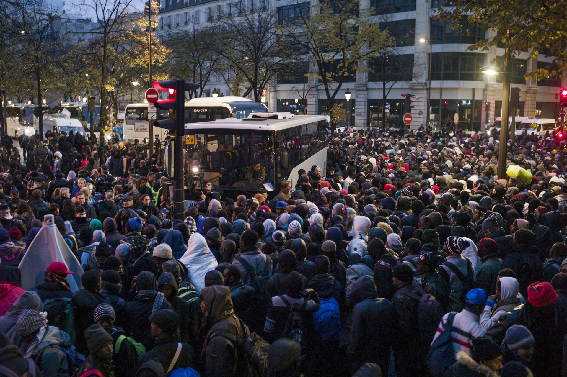 epa05617037 Migrants wait to get onto a bus during the evacuation of a makeshift camp in the 19th district of Paris, France, early 04 November 2016. French authorities started removing up to 2,500 migrants from the streets of Paris after camps in the city grew following the clearance of the so-called 'Jungle' camp in Calais, northen France, at the end of October 2016.  EPA/YOAN VALAT