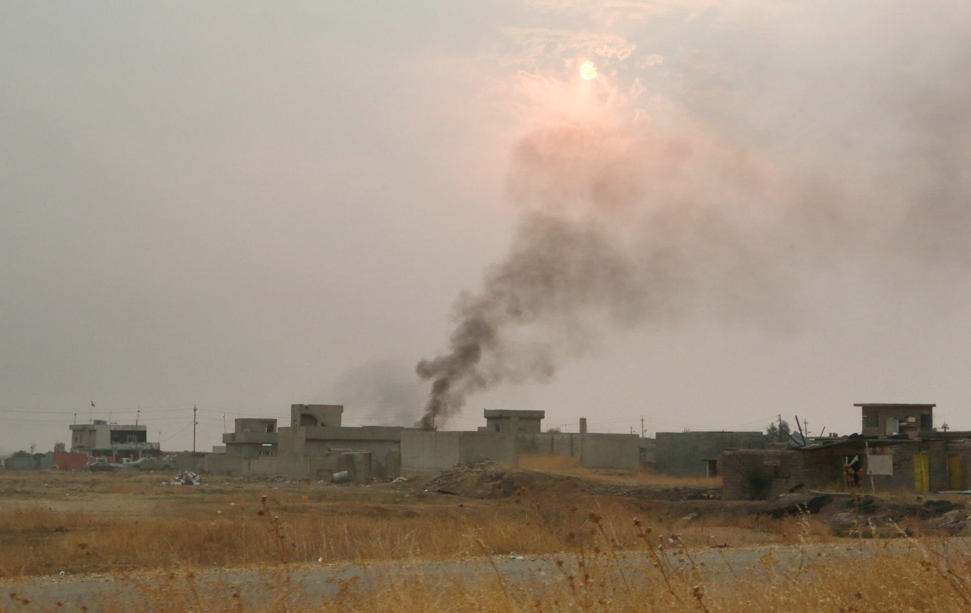 epa05601094 Smoke rises in different parts as the sun starts to set on the town of Bartila, some 27 km East of Mosul, Iraq, 24 October 2016. Iraqi officers told EPA on 24 October that the village of Khazna right after Bartila, as well as Mar Karamles and Hamdaniya have been liberated in the past 24 hours, but access to most of them was only possible with an Iraqi armored car as their streets have not been cleared of IEDs (Improvised Explosive Devices) yet. EPA reporters who were allowed in again into Bartila witnessed a sniper shots to which Iraqi forces responded with a mortar firing.  EPA/AMEL PAIN