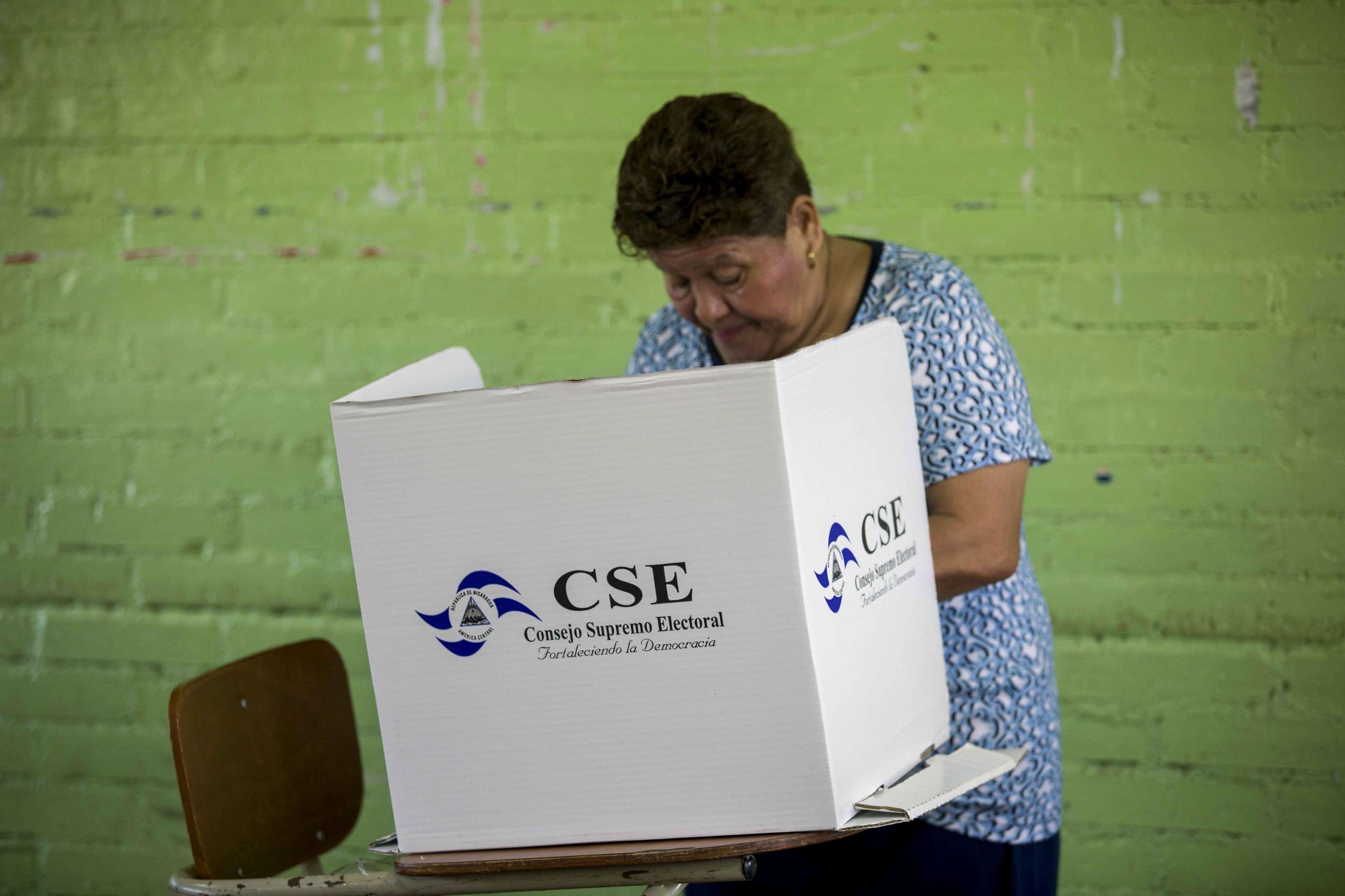 epa05619947 A Nicaraguan woman stands behind a cardboard voting booth while filling her ballot at a polling station during the country's general elections, in Managua, Nicaragua, 06 November 2016. Polling stations opened on 06 November for the presidential election in Nicaragua, in which six candidates, including the incumbent president Daniel Ortega, are vying to be the Central American nation's next head of state.  EPA/JORGE TORRES