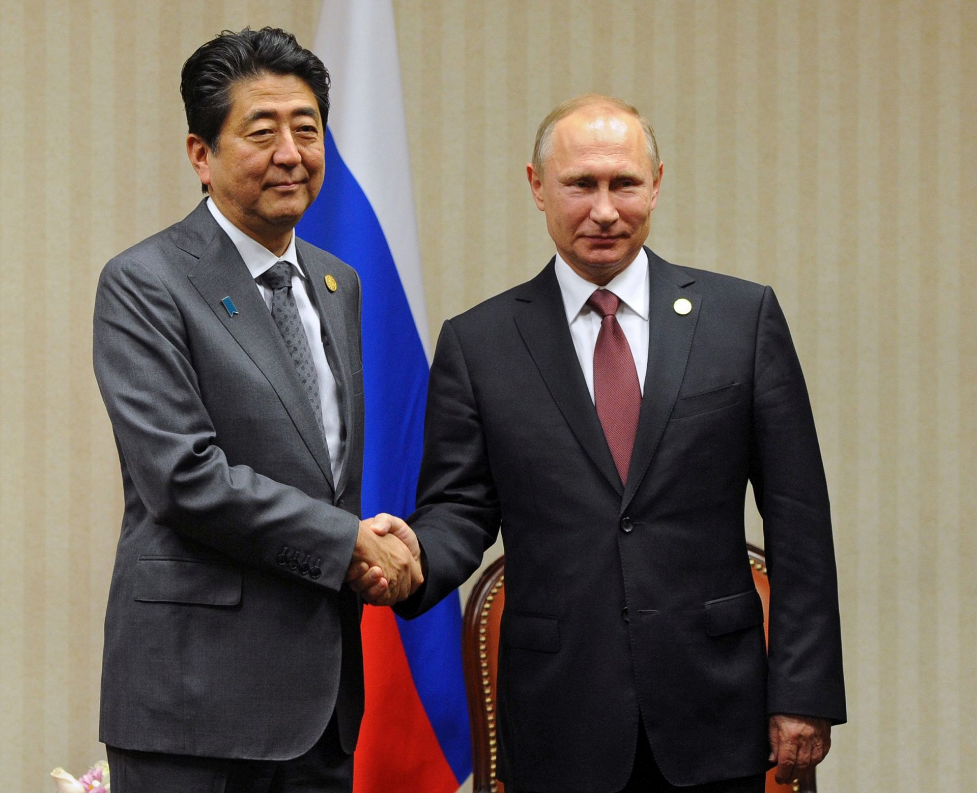 epa05639033 Russian President Vladimir Putin (R) and Japanese Prime Minister Shinzo Abe (L) shake hands during their meeting in Lima, Peru, 19 November 2016. The Asia-Pacific Economic Cooperation (APEC) Economic Leaders' Meeting takes place in Lima from 19 to 20 November 2016.  EPA/MIKHAIL KLIMENTYEV/SPUTNIK/KREMLIN POOL MANDATORY CREDIT