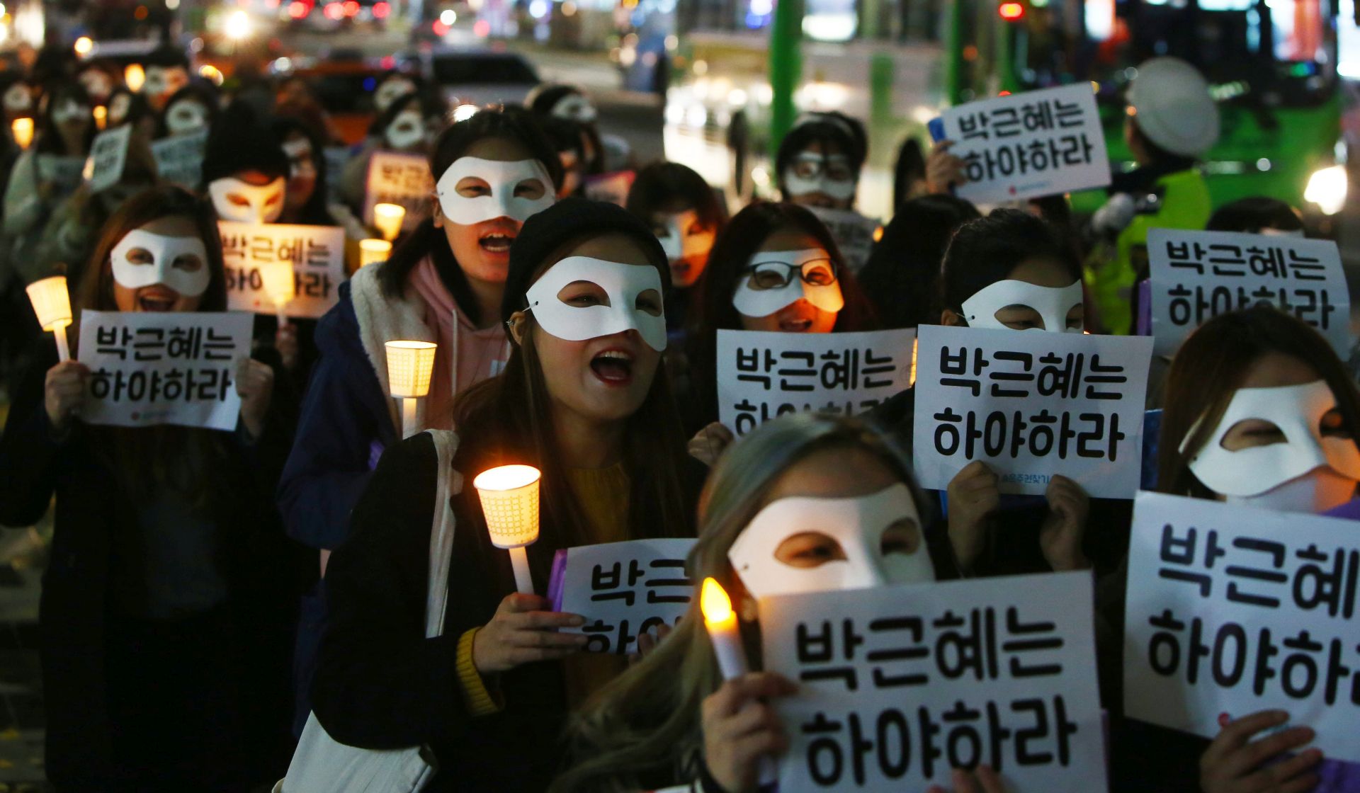 epa05632455 South Korean university students march with candlelight as they carry placards reading 'Park Geun-Hye Step Down' during a protest against South Korean President Park Geun-Hye on the street in Seoul, South Korea, 15 November 2016. The protesters gathered to demand South Koreans President Park Geun-Hye resignation after she has issued a rare public apology on 04 November after acknowledging close ties to Choi Sun-sil, who is in the center of a corruption scandal.  EPA/YANG JI-WOONG