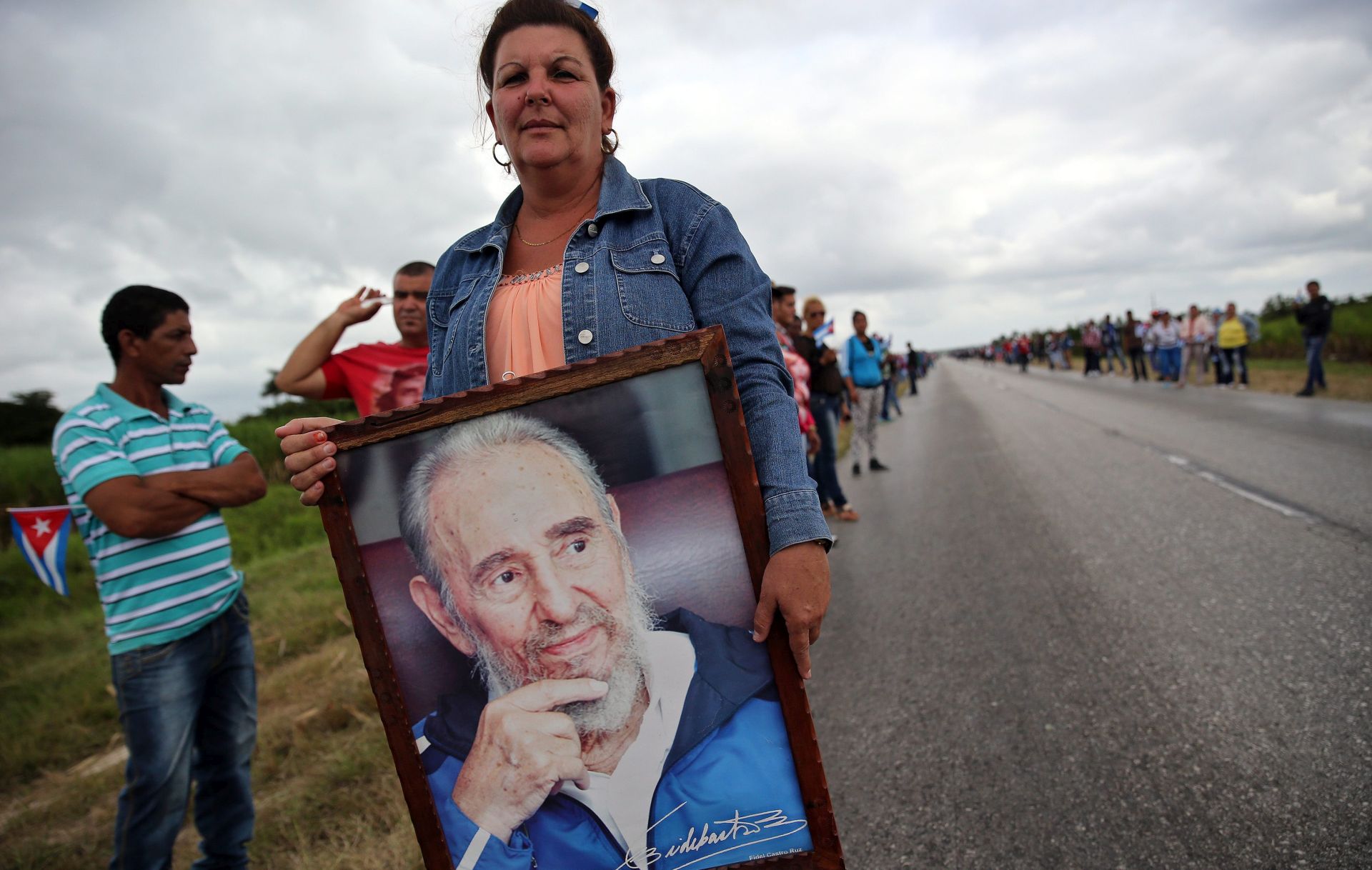 epa05655638 A woman waits for the passage of the urn with ashes of late Cuban leader Fidel Castro in Jatibonico, province of Sancti Spiritus, Cuba, 01 December 2016. The urn containing the ashes of Castro is on a four-day journey across the island, a funeral procession that will end in Santiago de Cuba, where his funeral will be held on 04 December 2016.  EPA/ALEJANDRO ERNESTO