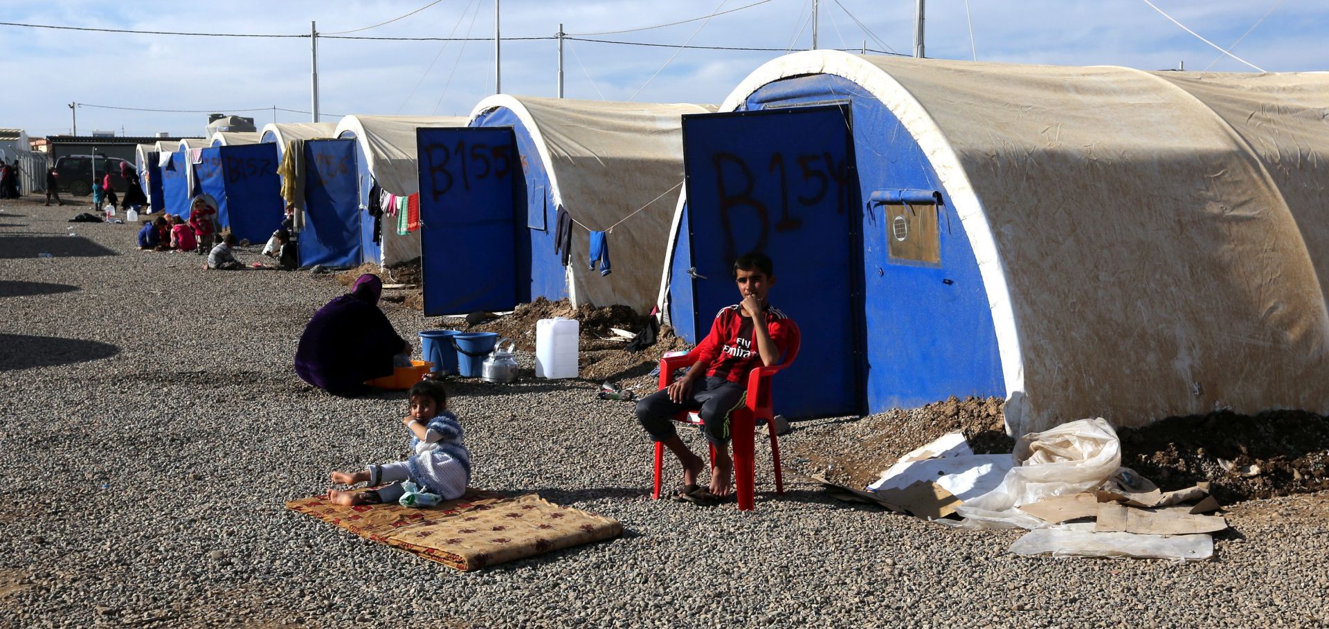epa05659705 Iraqi displaced people from Mosul sit near the tents at Khazir camp, east of Mosul, northern Iraq, 04 December 2016. According to the Iraqi Ministry of Displacement and Migration, the number of displaced people from Mosul is more than 85 thousand people since the start of offensive by Iraqi forces to liberate the city from Islamic State (IS) militants.  EPA/AHMED JALIL