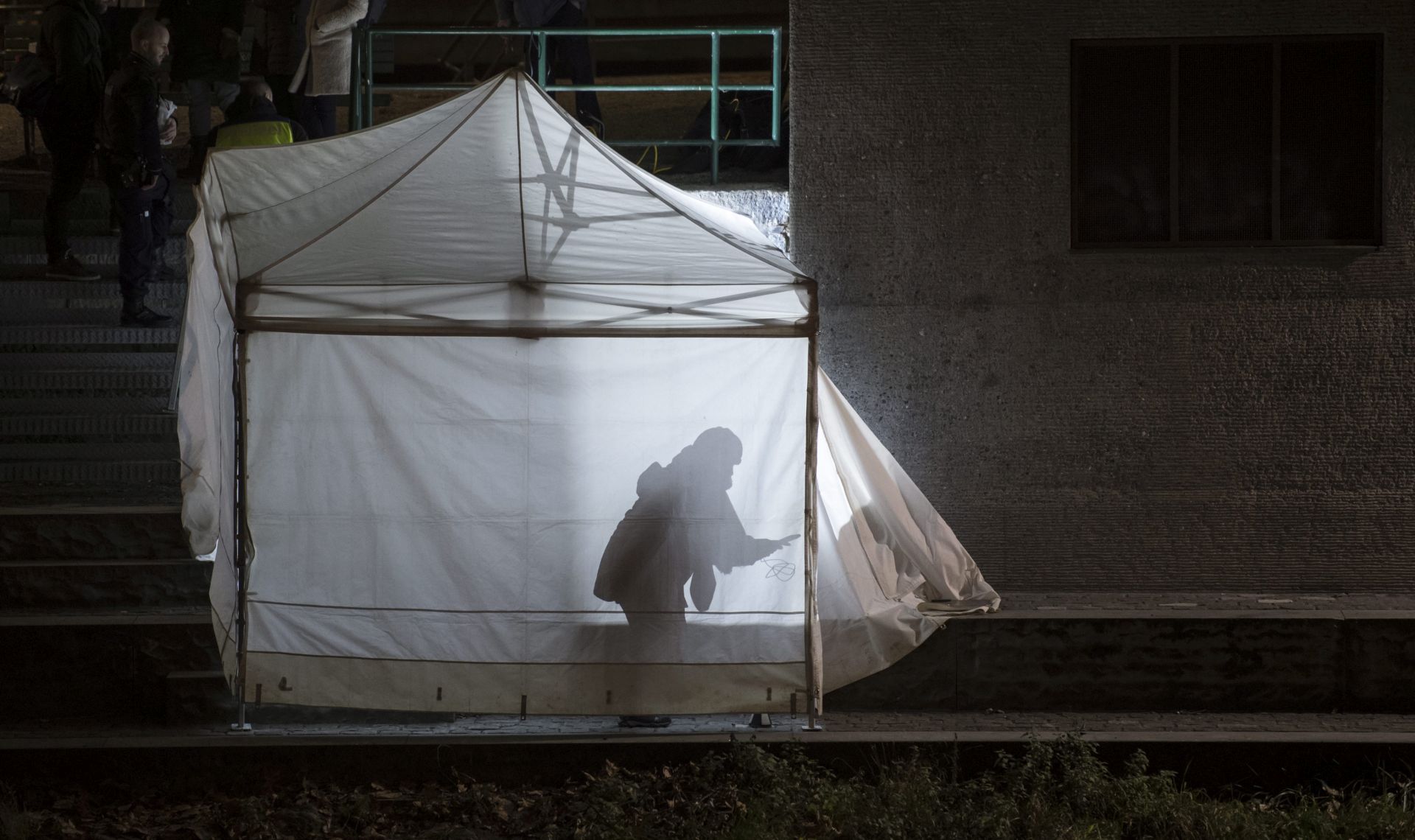 epa05682673 Policemen inspect the site where a body is found under the Gessnerbruecke bridge, after the shooting attacks at the Islamic center in Zurich, Switzerland, 19 December 2016. Three people were injured at the shooting near Zurich's main railway station. According to the police, the attackers are still on the run.  EPA/ENNIO LEANZA