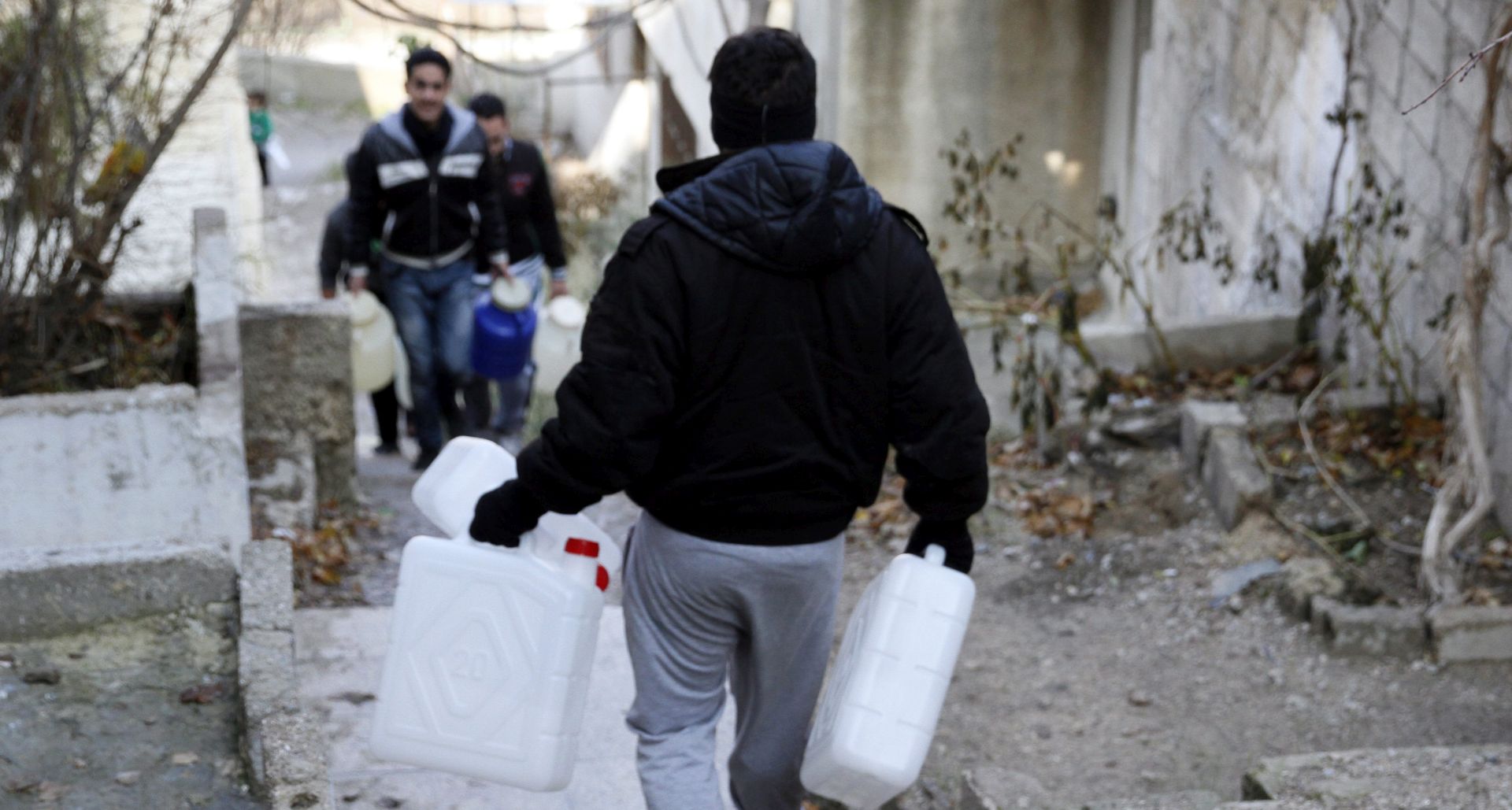 epa05690772 A man carries empty jerry-cans to be filled with water in Damascus, Syria, 29 December 2016. According to media reports, the capital Damascus has been suffering of water shortage for seven consecutive days. Rebels entrenching in Wadi Barada area in the west of Damascus have cut off water flowing from Ein al Feijeh water spring, the main water supply of Damascus city. al-Nusra Front's militants allegedly contaminated the spring with diesel and poured al-Feijeh water in Barada River. The Syrian government promised that the crisis would be resolved soon.  EPA/YOUSSEF BADAWI