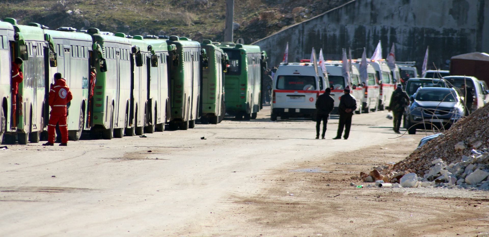 epa05677020 Busses and ambulances wait to evacuate fighters and their families from rebel-held zones in Aleppo, Syria, 15 December 2016. The evacuation of Aleppo began on 15 December as the first ambulances and buses extracted the sick and wounded from final rebel-held zones in the northern Syrian city, the Red Cross NGO said. Reports state the first batch of 951 gunmen and their families were evacuated via al-Ramouseh crossing to Aleppo southwestern countryside.  EPA/STR