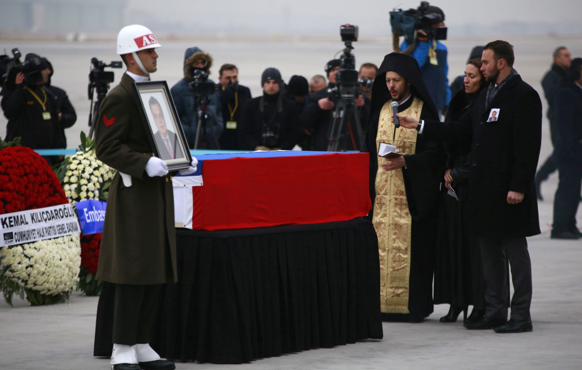 epa05683630 A priest offers prayers by the coffin of the murdered Russian ambassador to Turkey Andrey (Andrei) Karlov during a ceremony at Esenboga airport, shortly before the body was transported by plane, Ankara, Turkey, 20 December 2016. Andrey Karlov was fatally shot at an art exhibition in the Turkish capital of Ankara on 19 December 2016.  EPA/TUMAY BERKIN