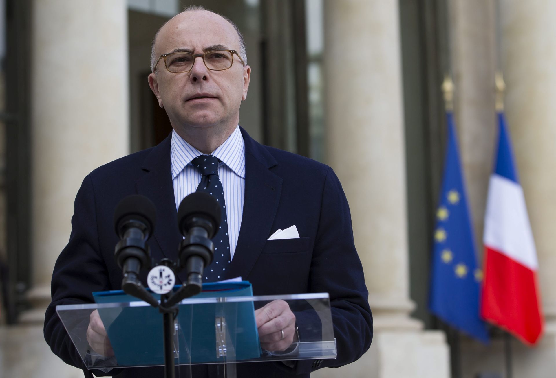 epa05225200 French minister of Interior delivers a statement to media after attending crisis defence meeting at the Elysee Palace in Paris, France, 22 March 2016. A crisis meeting took place place following blasts in the departure hall of Zaventem airport and several metro stations in Brussels, Belgium, with media reporting at least a dozen casualties. Cazeneuve announced that 1600 additional police officers and gendarmes in French transport hubs.  EPA/IAN LANGSDON