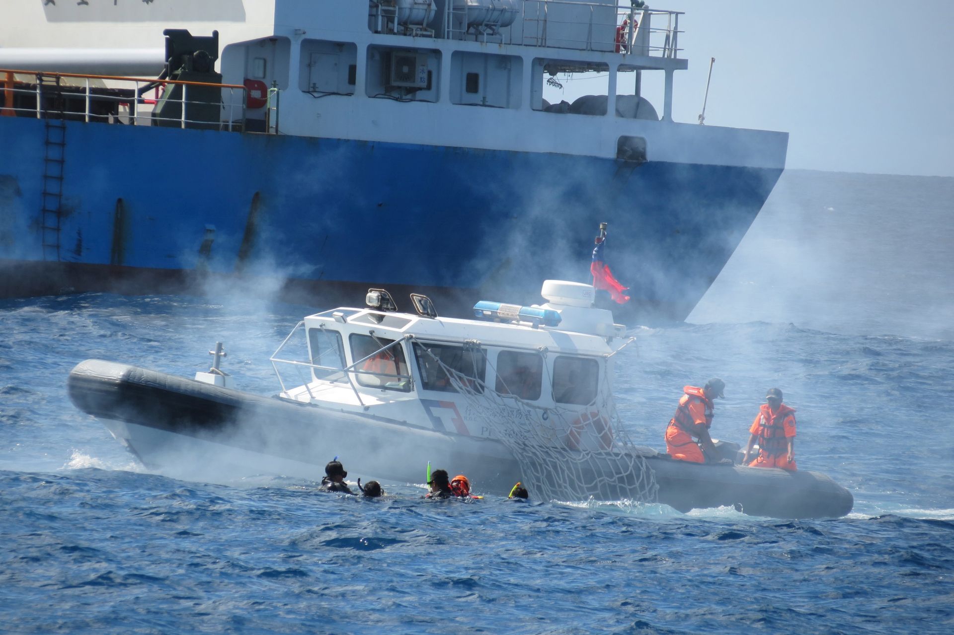epa05652124 A handout photo released by the Military News Agency on 29 November 2016, showing a search and rescue drill in which Taiwan Coast Guard personnel rescue an actor performing as a foreign sailor in the sea after a foreign ship (background) caught fire, near the Taiping Island in the disputed South China Sea, 29 November 2016. Taiwan held the drill to assert territorial claims and to tell the world that it is willing to provide humanitarian aid to foreign ships, sailors and fishermen. Taiping Island is claimed by China, Taiwan and the Philippines.  EPA/MILITARY NEWS AGENCY HANDOUT  HANDOUT EDITORIAL USE ONLY/NO SALES