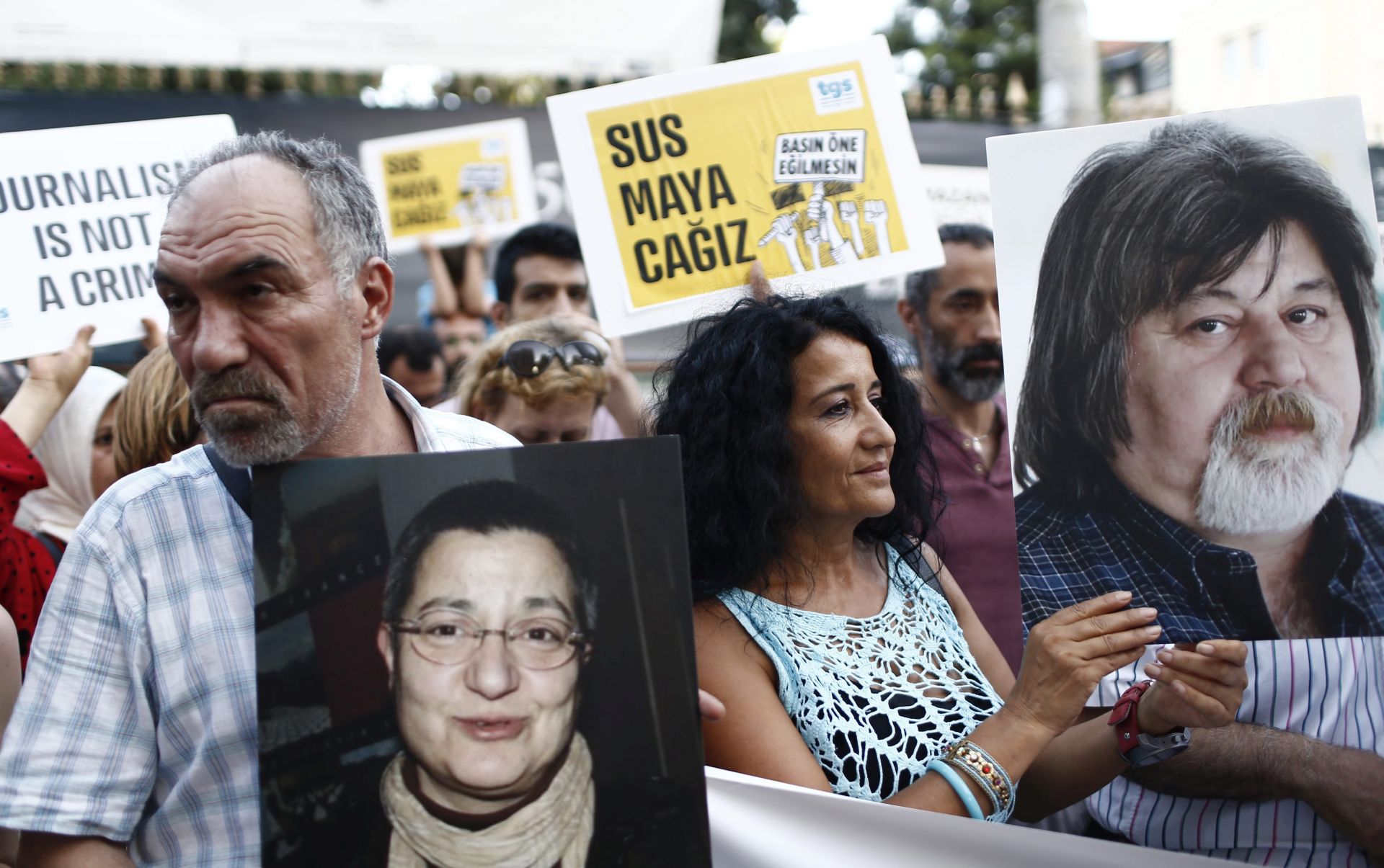 epa05381877 Journalists shout slogans as they hold the picture of three arrested academic and journalist, near theTaksim Square in Istanbul, Turkey, 21 June 2016. Erol Onderoglu, Ahmet Nesin and Sebnem Korur Fincanci were arrested and charged with promoting terrorism after being editor in cheif to Ozgur Gundem Newspaper for one day, to support the newspaper. According to media reports on 21 June 2016, Erol Onderoglu, along with journalist Ahmet Nesin and academic Sebnem Korur Fincanci, was placed under pretrial arrest by a Turkish court over charges of spreading 'terrorist propaganda.' The RSF commented on the arrest as 'an unbelievable low' for press freedom in Turkey, media quoted as saying.  EPA/SEDAT SUNA