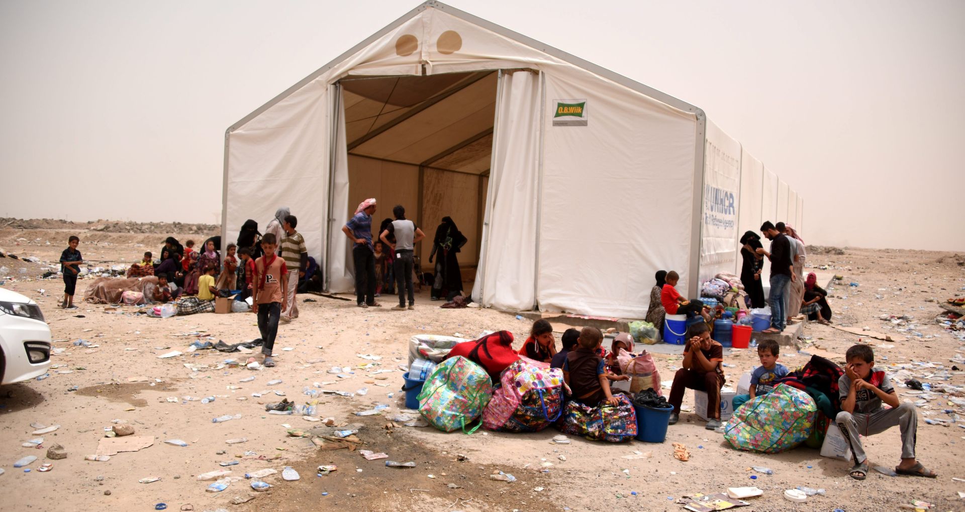 epa05383701 A handout photograph made available on 22 June 2016 by the humanitarian organization, Norwegian Refugee Council (NRC) showing displaced Iraqis from Fallujah stranded in Amariyat Al Fallujah, just before the Bzeibiz Bridge, waiting to be allowed into Baghdad, Iraq, 18 June 2016. According to UN High Commissioner for Refugees (UNHCR) Iraqis fled their homes in Fallujah city due the ongoing fighting between the Iraqi forces and Islamic State (IS) militants.  EPA/KARL SCHEMBRI/NRC  HANDOUT EDITORIAL USE ONLY/NO SALES
