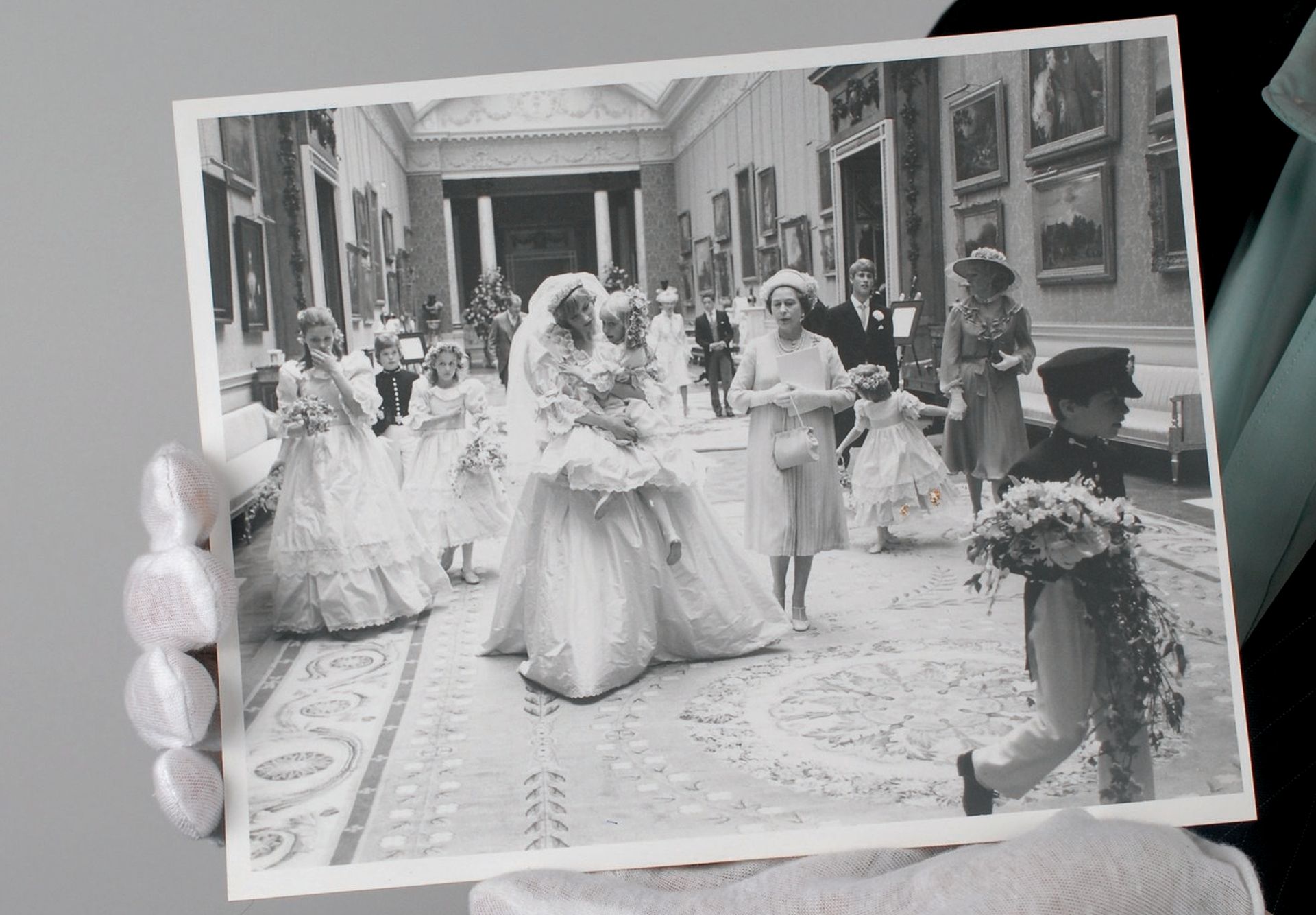 epa04881193 An undated handout shows RR Auction's Executive Vice President Bobby Livingston holding an unpublished photograph, of British Diana Princess of Wales (C) holding bridesmaid, five-year-old Clementine Hambro next to Britain's Queen Elizabeth II (3-R) at Buckingham Palace during her wedding with Britain's Prince Charles on 29 July 1981, in Amherst, Massachusetts, USA. The images from 1981 are believed to have been taken by British Lord Patrick Lichfield and are to be auctioned by RR Auction in Boston, Massachusetts, USA on 24 September 2015.  EPA/RR AUCTION HANDOUT ATTENTION EDITORS: FOR EDITORIAL USE ONLY IN CONNECTION WITH CURRENT REPORTING AND NOT FOR SALE HANDOUT EDITORIAL USE ONLY/NO SALES HANDOUT EDITORIAL USE ONLY/NO SALES