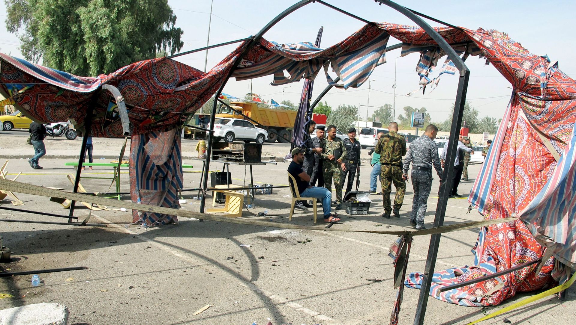 epa05587709 Iraqi policemen inspect the scene of a suicide bomb attack at Jadriyah district in central Baghdad, Iraq, 16 October 2016. At least four Shiites worshipers were killed and seven others were wounded when a suicide bomber blew himself inside a tent built to celebrate the annual Shiite Ashura festival in Baghdad, security officials said.  EPA/ALI ABBAS