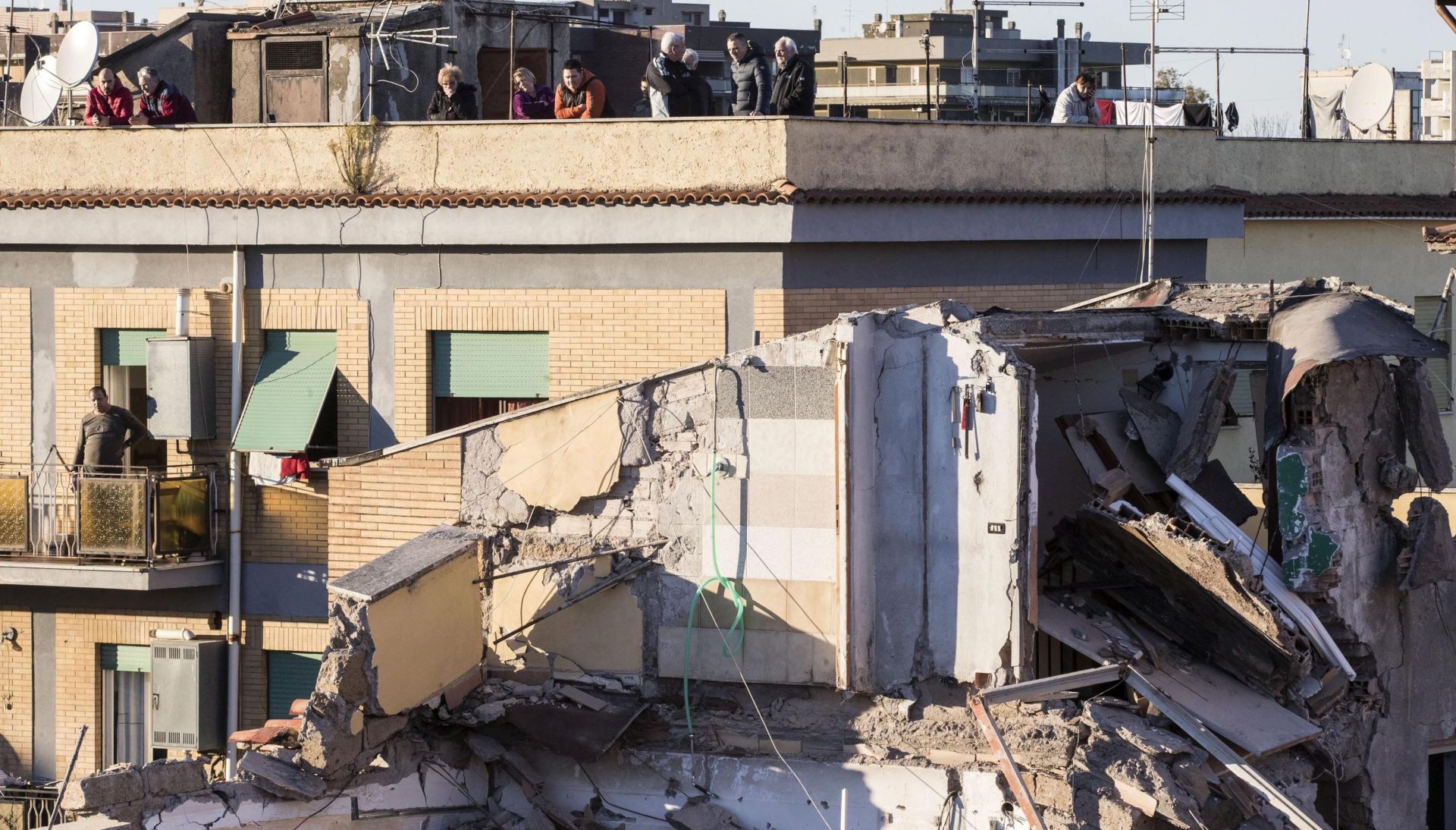 epa05690122 Firefighters work at a collapsed two-storey building in Acilia, Italy, 28 December 2016. Two people were pulled alive from the rubble of the house that collapsed probably because of a gas leak.  EPA/MASSIMO PERCOSSI