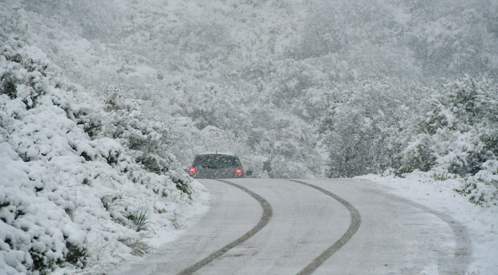 epa05703714 A motorist drives on a snow covered road as snow falls in Argos, Peloponnese, Greece, 07 January 2017. A cold wave across Greece causing temperatures to drop drastically brought snow fall to many cities of Greece.  EPA/VANGELIS BOUGIOTIS