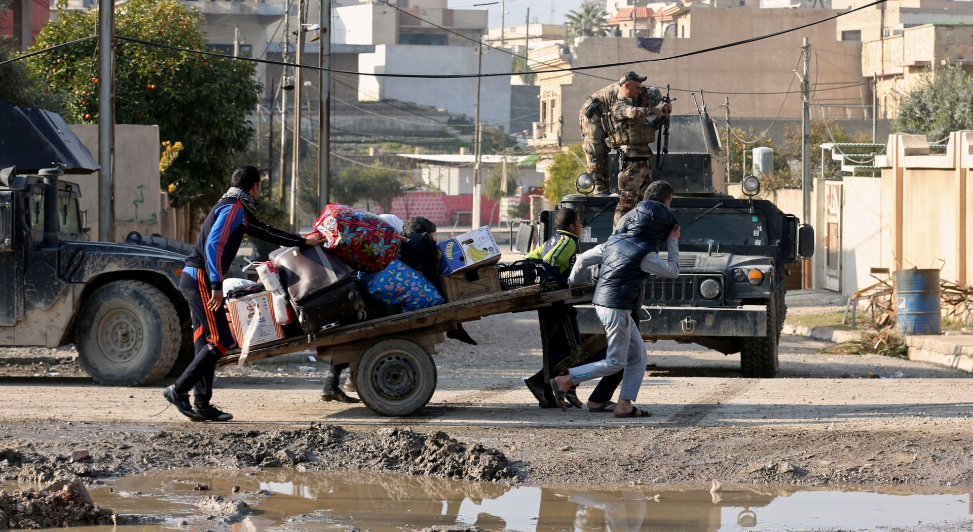 epa05705743 An Iraqi family leave Zuhor district due the ongoing fighting between the Iraqi forces and Islamic state fighters (IS) in Mosul, northern Iraq on 08 January 2017. A military official claims that the US-backed Iraqi special forces have reached the eastern bank of the River Tigris in Mosul for the first time and taken control of two districts in eastern Mosul, during an operation to drive Islamic State militants out of the city.  EPA/AHMED JALIL