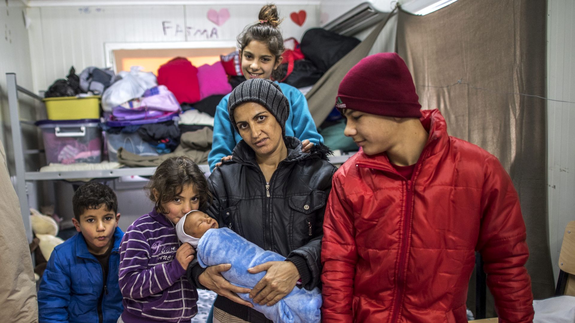 epa05728150 Shirin Kurdi, 32, mother of five children, holds her newly born baby Iljaz Rasul (five days old) in her barrack at the transit center for refugees and migrants near northern Macedonian village of Tabanovce on the border with Serbia, The Former Yugoslav Republic of Macedonia, 18 January 2017. Shirin Kurdi (Syrian Kurd) with her children are stuck in the transit camp for the last 10 months. According to the director of the transit center, Goran Stojanovski, there are currently 102 staying refugees and migrants at the center.  EPA/GEORGI LICOVSKI