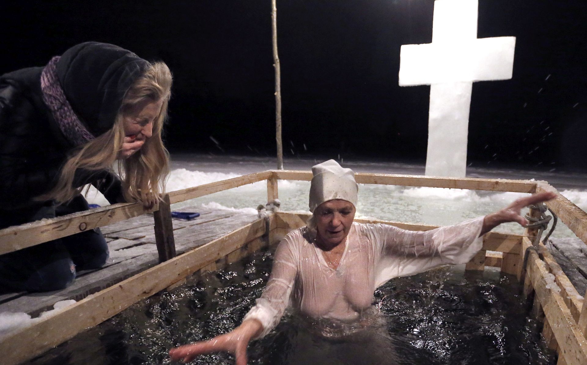 epa05729028 A Russian Orthodox believer takes a dip in the ice cold water of a pond during the celebrations of the Epiphany Orthodox holiday, in Chekhov, Moscow Region, Russia, early 19 January 2017. People believe that dipping into blessed water during the holiday of Epiphany strengthens their spirit and body.  EPA/MAXIM SHIPENKOV