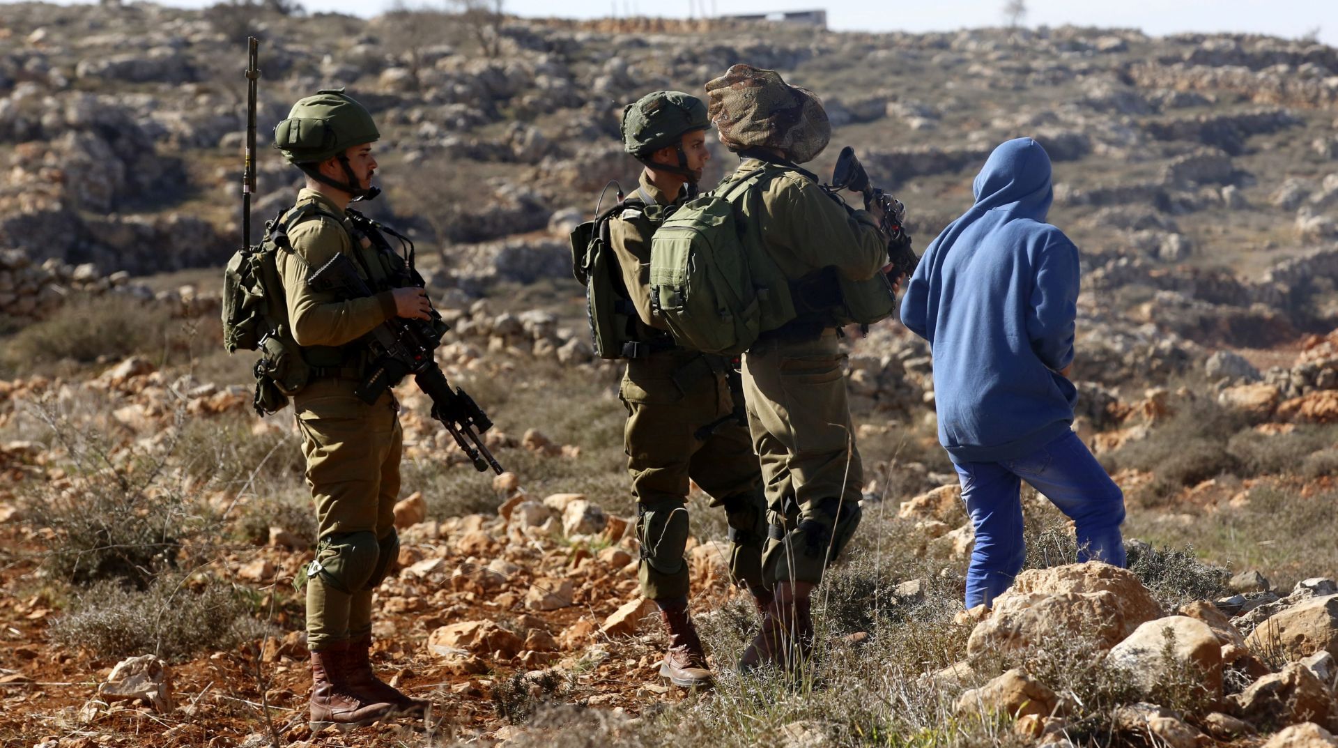 epa05734502 Israeli soldiers stop Palestinian boy during clashes between Israeli soldiers and Palestinians in the West Bank village of Qusra, near the city of Nablus, 20 January 2017. According to reports, the Palestinian villagers briefly detained a group of Israeli settlers, accusing them of having thrown rocks at farmers tending to their fields near the village. After a short period of time the Israeli troops arrived and removed the detained settlers and fire tear gas to stop Palestinians.  EPA/ALAA BADARNEH