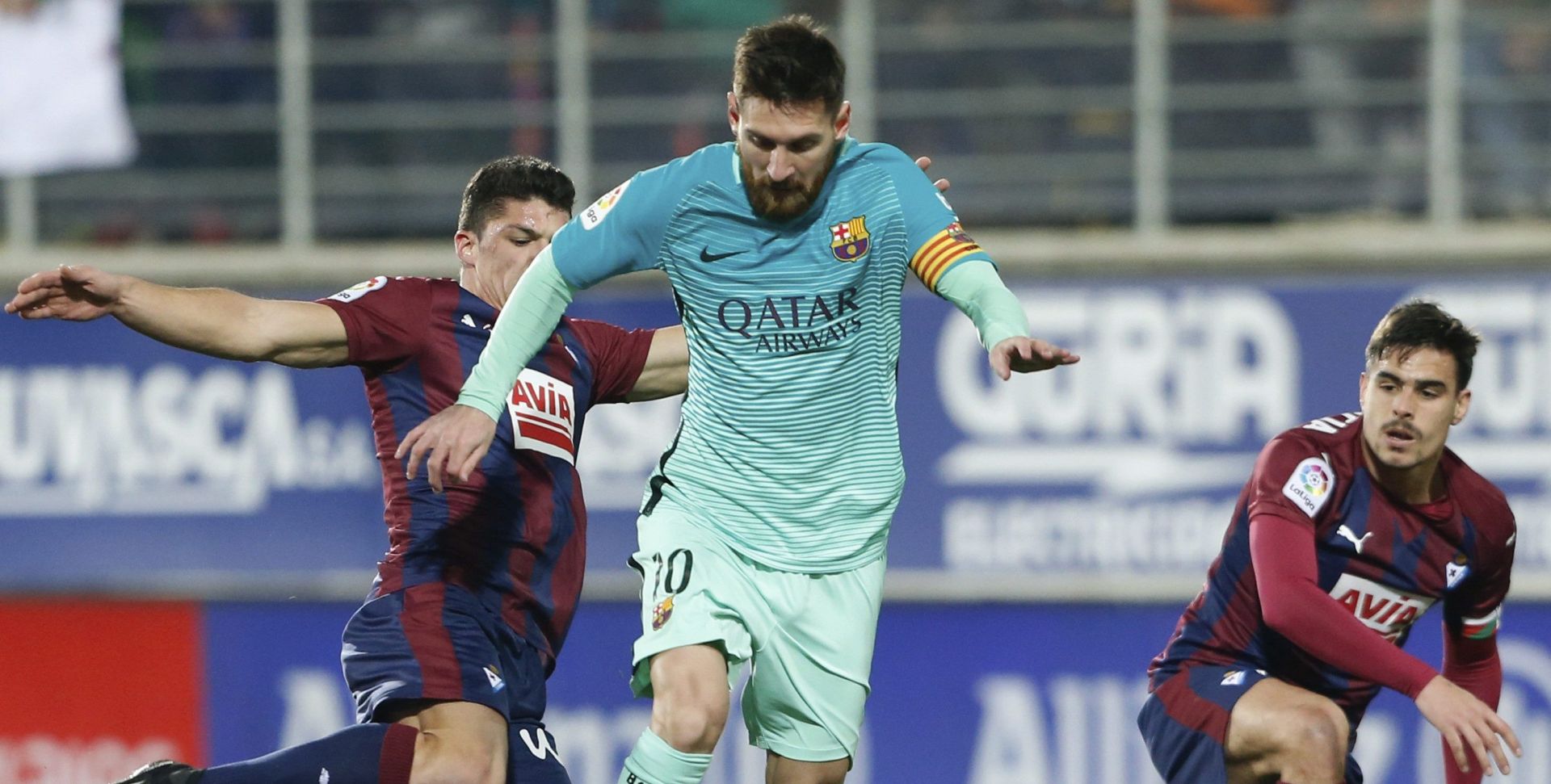 epa05742496 FC Barcelona's Argentinean forward Leo Messi (C) escapes between Ander Capa (L) and Dani Garcia (R), both of Eibar, during their Spanish Primera Division soccer match played at the Ipurua stadium in Eibar, Spain, on 22 January 2017.  EPA/JUAN HERRERO