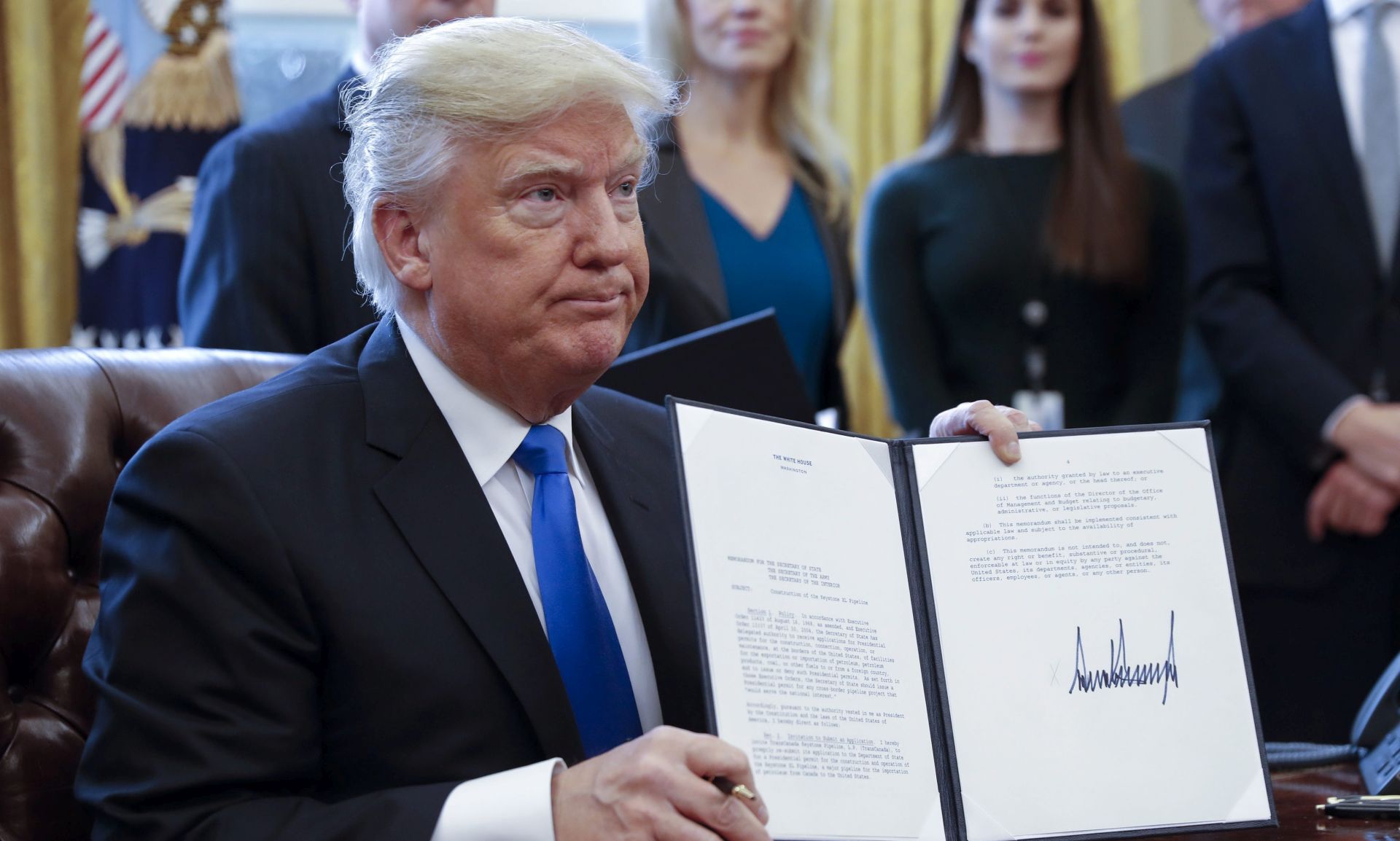 epa05747101 US President Donald Trump displays one of five executive orders he signed related to the oil pipeline industry in the oval office of the White House in Washington, DC, USA, 24 January 2017. US President Trump on 24 January 2017 signed an executive order that allows the disputed Dakota Access and Keystone XL pipelines, under the precondition that US-American steel was used. Former president Obama's administration in 2015 halted the controversial Keystopne XL project.  EPA/SHAWN THEW