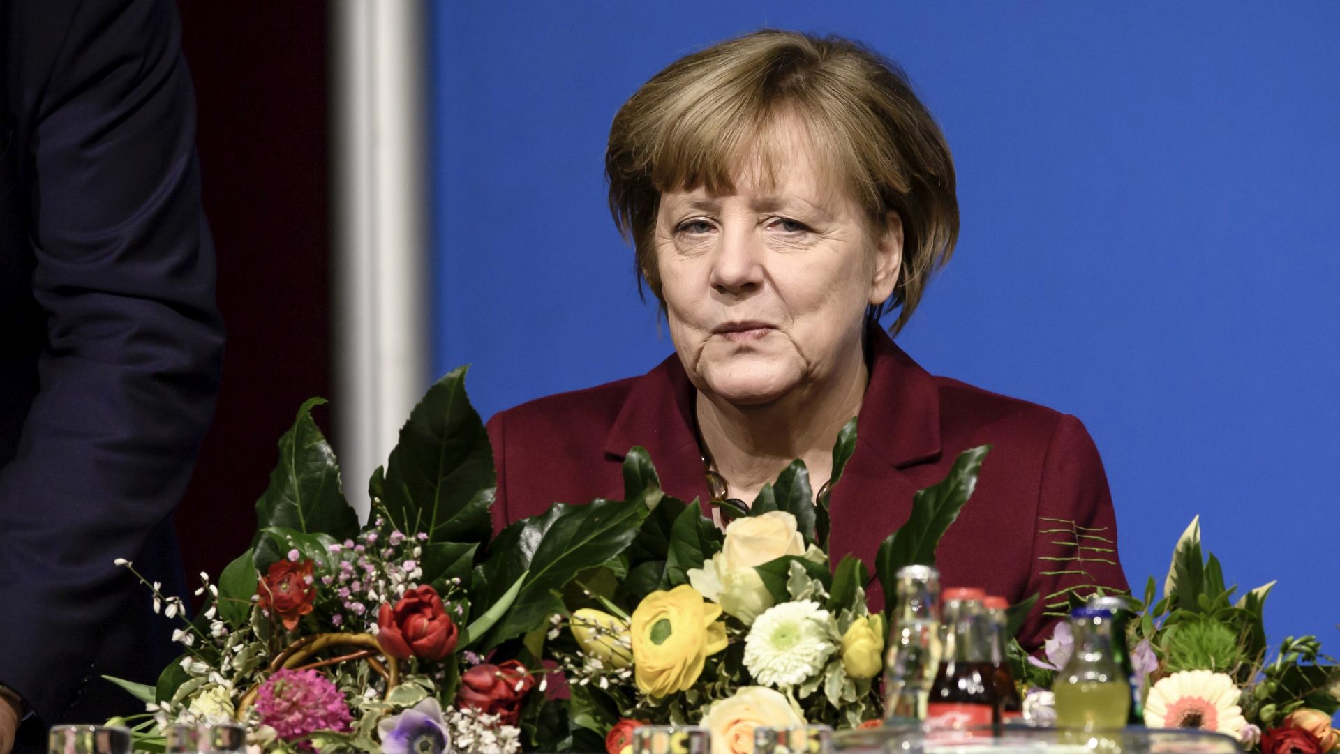 epa05756452 German Chancellor Angela Merkel sits behind flowers after her reelection during a gathering of the Christian Democratic Union (CDU) party in her electoral district in Grimmen, Germany, 28 January 2017. Merkel visited her constituency in Mecklenburg-Western Pomerania on the occasion of her confirmation as candidate for the German parliament elections in September 2017.  EPA/CLEMENS BILAN