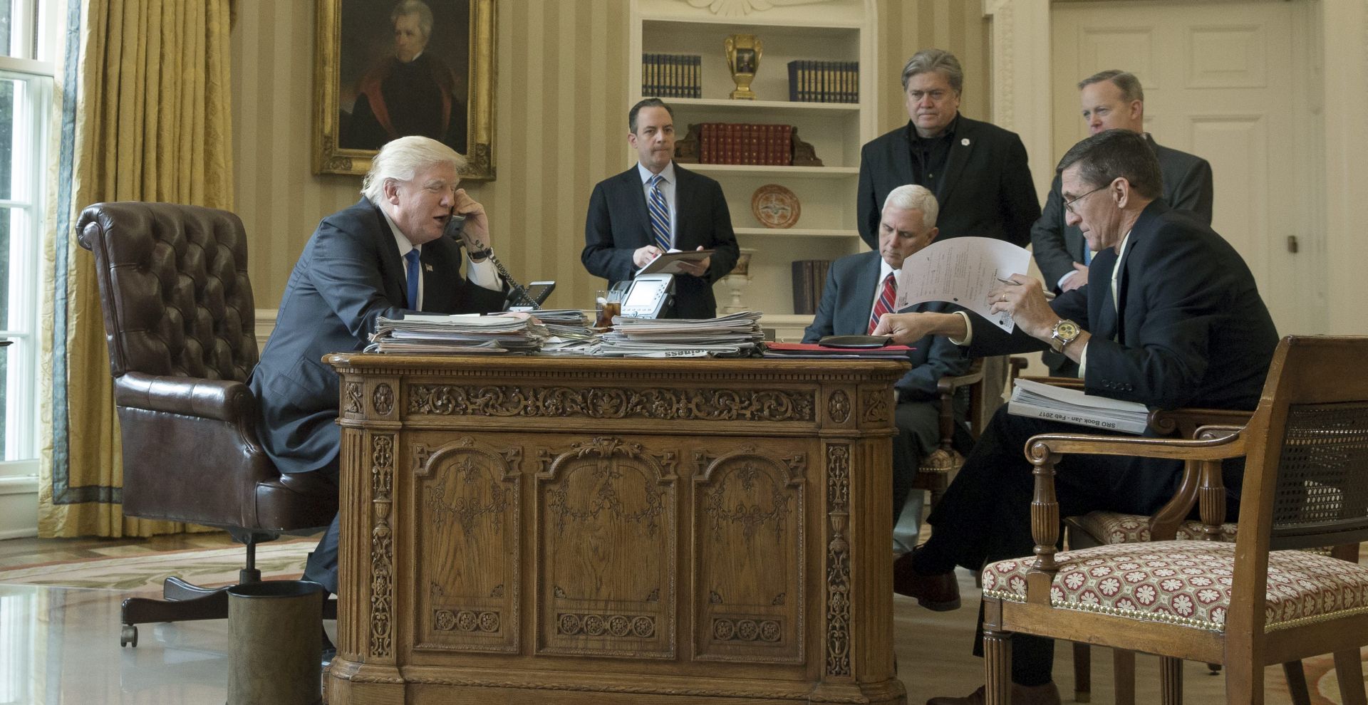 epa05757527 US President Donald J. Trump (L) speaks on the phone with President of Russia Vladimir Putin, in the Oval Office of the White House in Washington, DC, USA, 28 January 2017. President Trump has chosen the day to talk with different world leaders, significantly Russia's Vladimir Putin and Germany's Angela Merkel by telephone. Also in this picture; White House Chief of Staff Reince Priebus (2-L), US Vice President Mike Pence (3-L),  Chief Strategist and Senior Counselor Stephen Bannon (3-R), White House Press Secretary Sean Spicer (2-R) and National Security Advisor, retired Lieutenant General Michael Flynn.  EPA/MICHAEL REYNOLDS