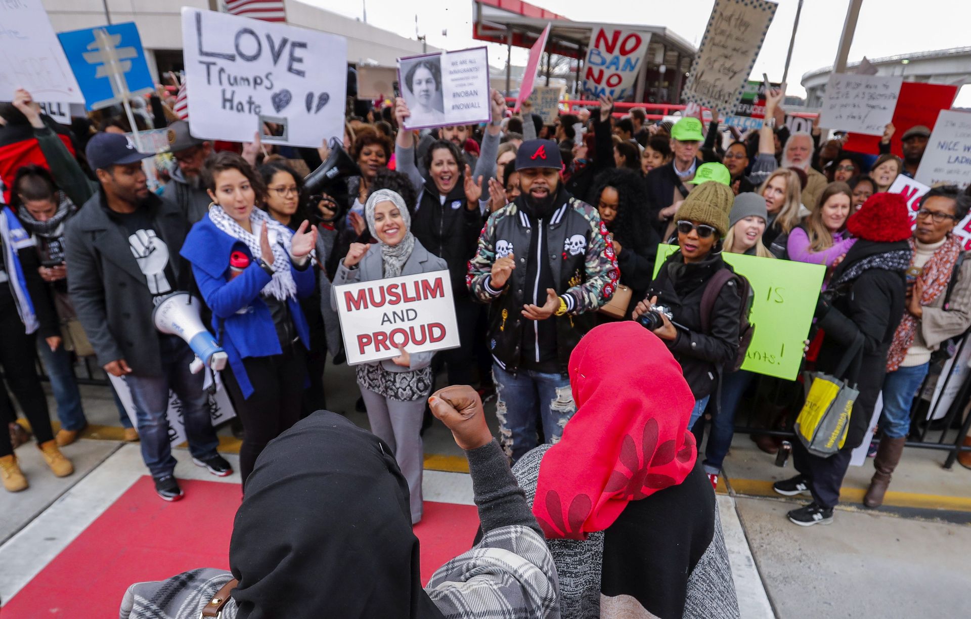epa05760537 People gather and hold signs during a protest at Hartsfield-Jackson Atlanta International Airport after new immigration policies enacted by US President Donald Trump in Atlanta, Georgia, USA, 29 January 2017. A Federal judge in New York issued an emergency stay for parts of Trump's executive order affecting US-bound travelers from seven predominantly Muslim countries.  EPA/ERIK S. LESSER