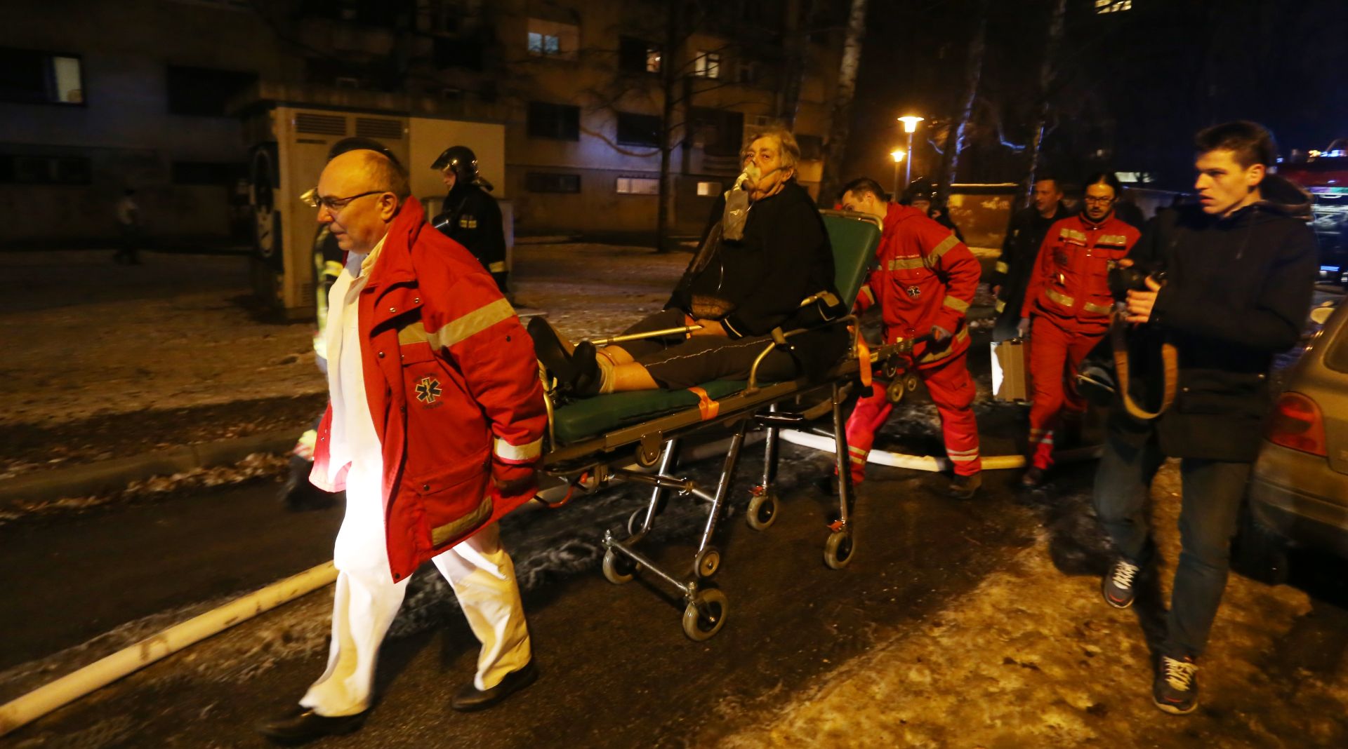 26.01.2016., Zagreb - U vecernjim je satima planuo stan u prizemlju zgrade u Ulici Sime Starcevica 5 u Folnegovicevom naselju. Na teren su odmah izasli vatrogasci sa sedam vatrogasnih kamiona,a pozar su ukupno gasila 24 vatrogasca. Iz plamteceg stana spasena je gospodja koja se nagutala dima, zbrinula ju je Hitna pomoc. 
Photo: Igor Soban/PIXSELL
