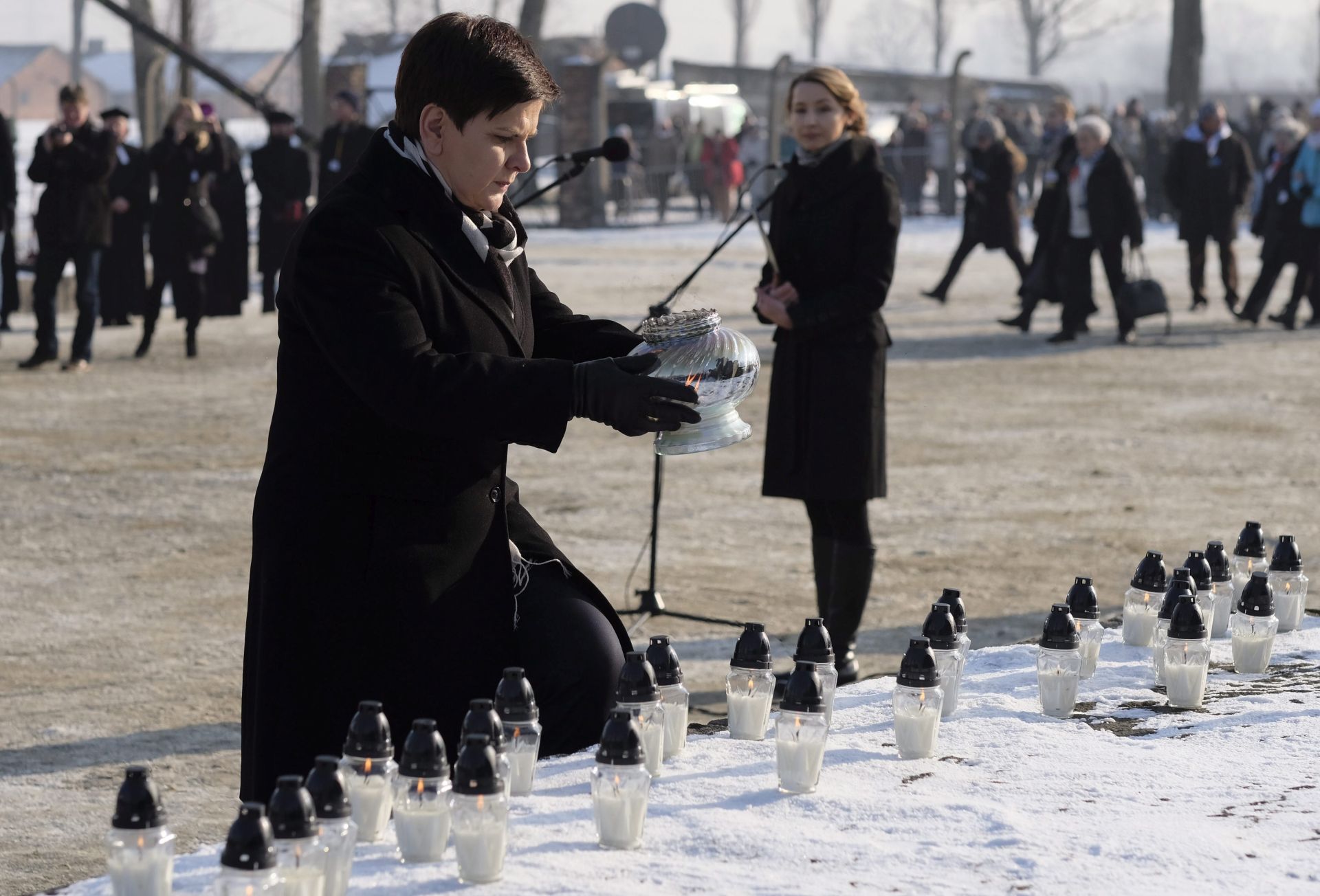 epa05754330 Polish Prime Minister Beata Szydlo lights candles at the International Monument to the Victims of Fascism after a ceremony marking the 72nd anniversary of the liberation of Auschwitz-Birkenau, in Oswiecim, Poland, 27 January 2017. The biggest German Nazi death camp KL Auschwitz-Birkenau was liberated by the Soviet Red Army on 27 January 1945. The world commemorates its liberation by International Holocaust Remembrance Day annually on 27 January.  EPA/Andrzej Grygiel POLAND OUT