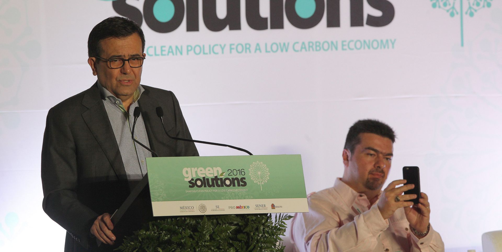 epa05661711 The Mexican Economy Minister, Ildefonso Guajardo (L), speaks during the start of the Green Solutions 2016 event at the UN Biodiversity Conference in Cancun, Mexico, 05 December 2016. The conference, governened by the Conference of Parties, is organized to ensure the implementation of international agreements to protect biodiversity.  EPA/ALONSO CUPUL