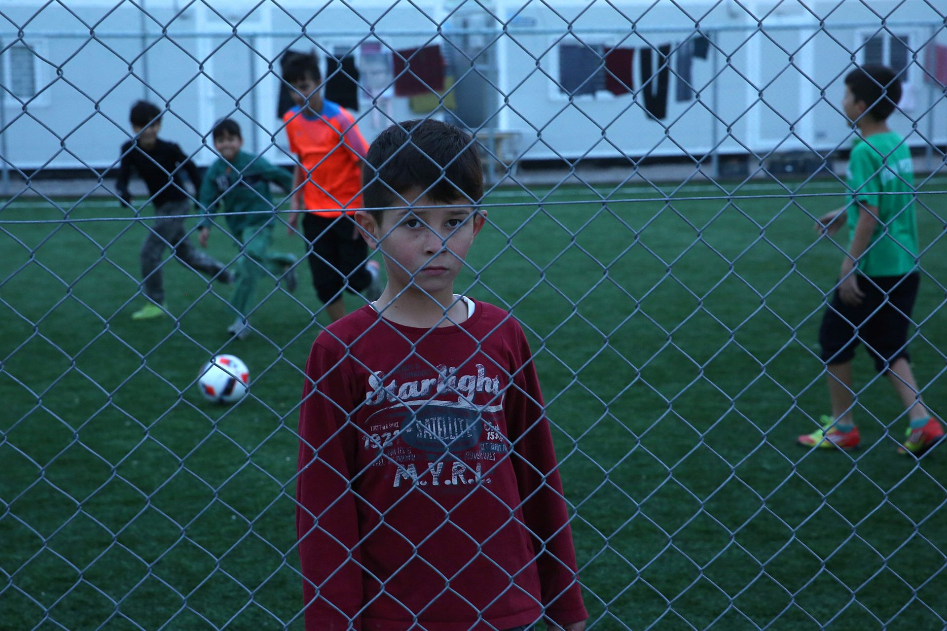epa05725078 Refugee children play soccer in the Eleonas refugee camp in central Athens, Greece, 17 January 2017. Some 2,000 refugees from Syria, Iraq, Afghanistan and Sierra Leone live in the camp waiting for their relocation to other European countries.  EPA/ORESTIS PANAGIOTOU