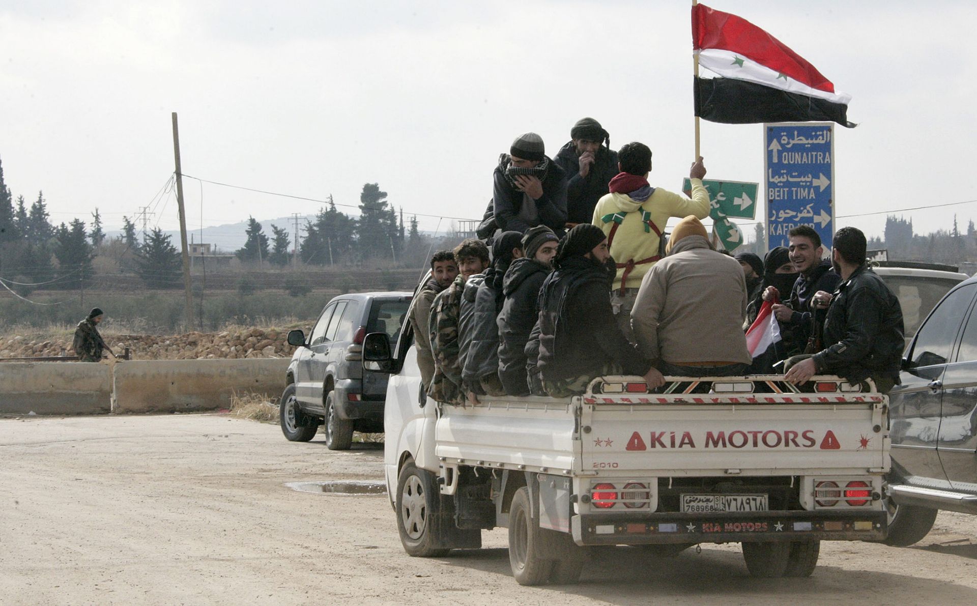 epa05700273 A handout picture made available by Syrian Arab news agency shows Syrian gunmen carry the Syrian national flag as they sit aboard a truck after registering their names and hand over their weapons to get a legal status in the southwestern countryside of Damascus, Syria, 05 January 2017. SANA reporter said 200 gunmen from Beit Saber, Beit Tima, Saasaa al-Gharbiyeh, Hassno and Kafar Hour in the western part of Damascus Countryside had turned themselves in and handed over their weapons to the authorities and pledged to not get involved in any act that might harm the homeland's security in the future. Chairman of the Local Reconciliation Committee in the countryside of Damascus and Daraa Mou'men Jarida said the region will be fuly cleared of gunmen and arms so that the state establishments will operate normally again.  EPA/SANA HANDOUT  HANDOUT EDITORIAL USE ONLY/NO SALES