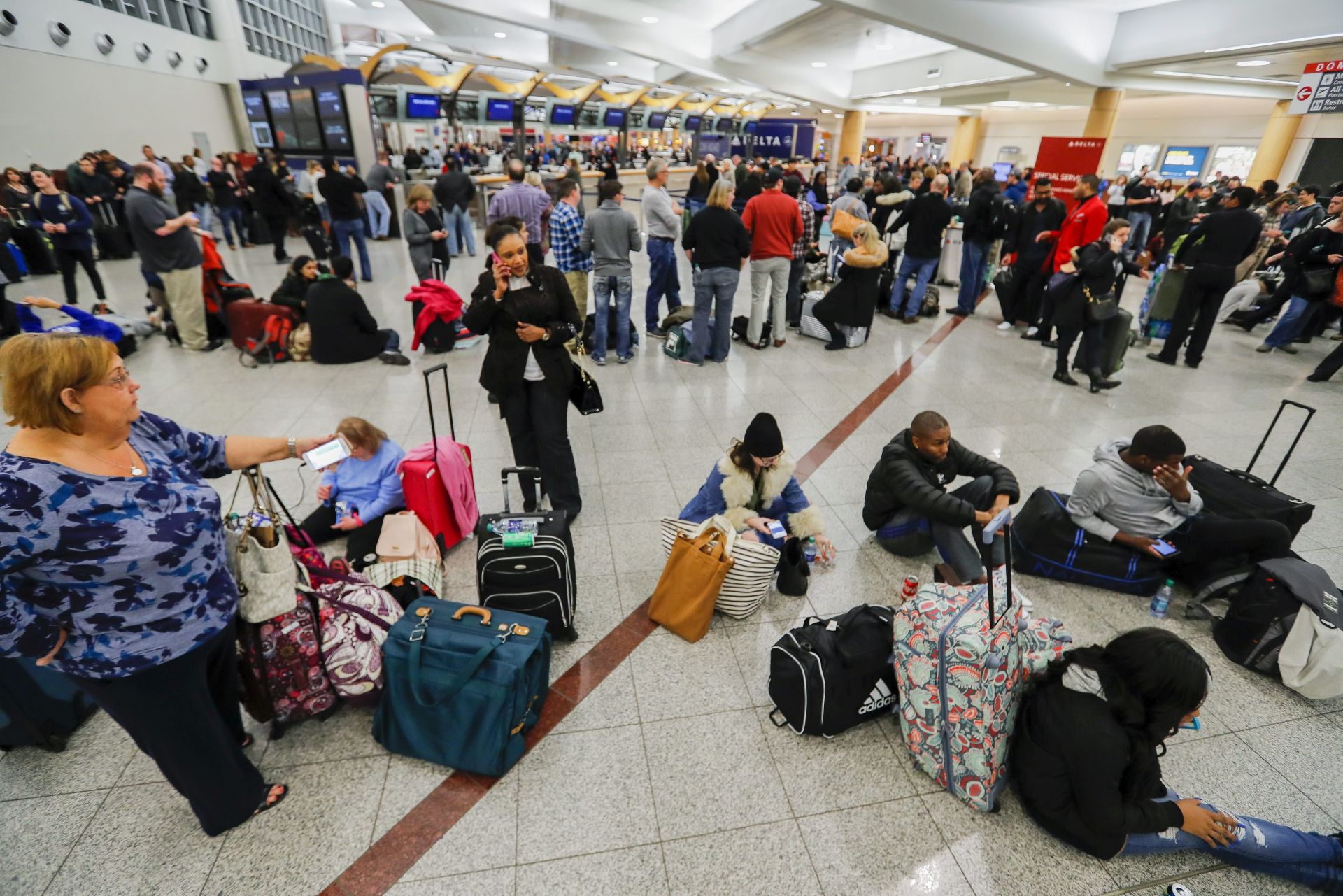 epa05760718 Stranded Delta Air Lines passengers wait to check in at the main terminal at Hartsfield-Jackson Atlanta International Airport after the Federal Aviation Administration reported that automation issues grounded all Delta US domestic flights in Atlanta, Georgia, USA, 29 January 2017.  EPA/ERIK S. LESSER