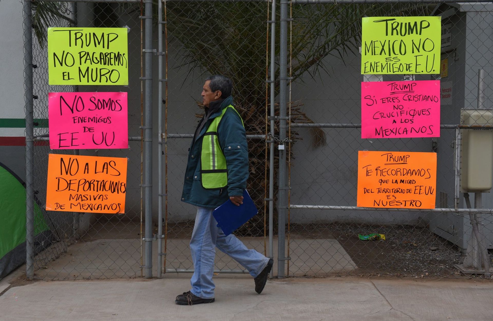 epa05736334 View of posters reading 'Trump, we are not going to pay for a wall', 'Mexico is not an enemy of the United States', 'Not to massive deportations' hang on fence on the border line of Mexicali in Mexico, and Calexico in the United States, in Mexicali, Mexico, 20 January 2017. Donald J. Trump was sworn in as the 45th President of the United States of America on 20 January 2017.  EPA/JUAN BARACK